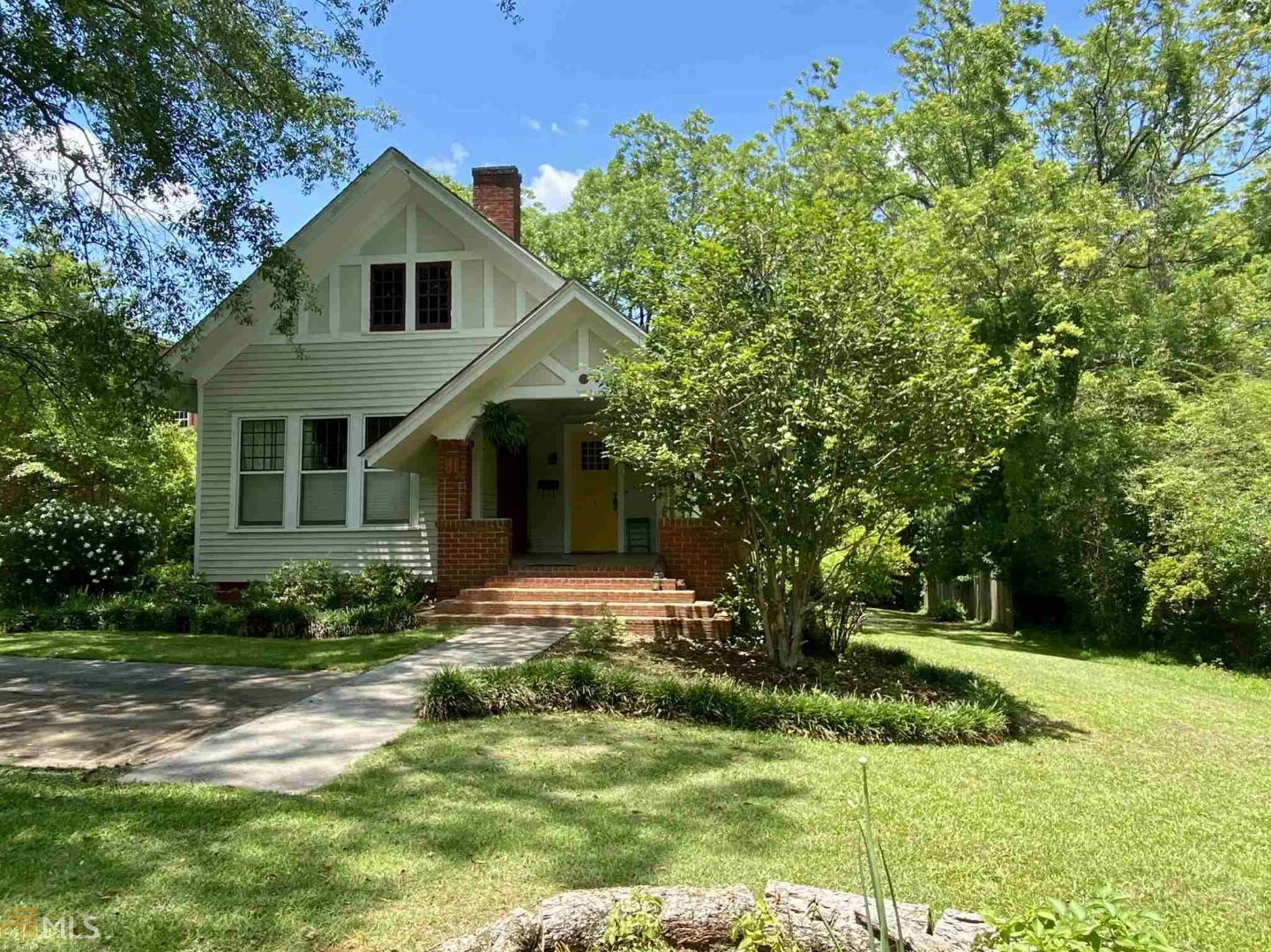 Circa 1910. This Craftsman style home is said to have won first place in an "Architectural Competition" to convert a commercial building into a home. Intricate details galore include wood floors, 12-paned windows, picture molding, coffered ceilings, judges paneling in dining room, antique door knobs, painted brick fireplaces, 2 fireplaces have authentic gas coal fire with Evans baskets, plantation shutters & 12 ft ceilings throughout. Both bedrooms have fireplaces, closets, ceiling fans and easy access to bathroom with claw foot tub/shower, believed to come from the Old Biltmore Hotel in Atlanta. The kitchen is enhanced with checkered board floors, solid surface counter-tops & subway tile backsplash. The exterior of the home is enhanced with a covered front porch, screened back porch, Savannah-style brick stairs & a garage which is rumored to be the first garage in town that housed the first car in town. So much history, so much to see..