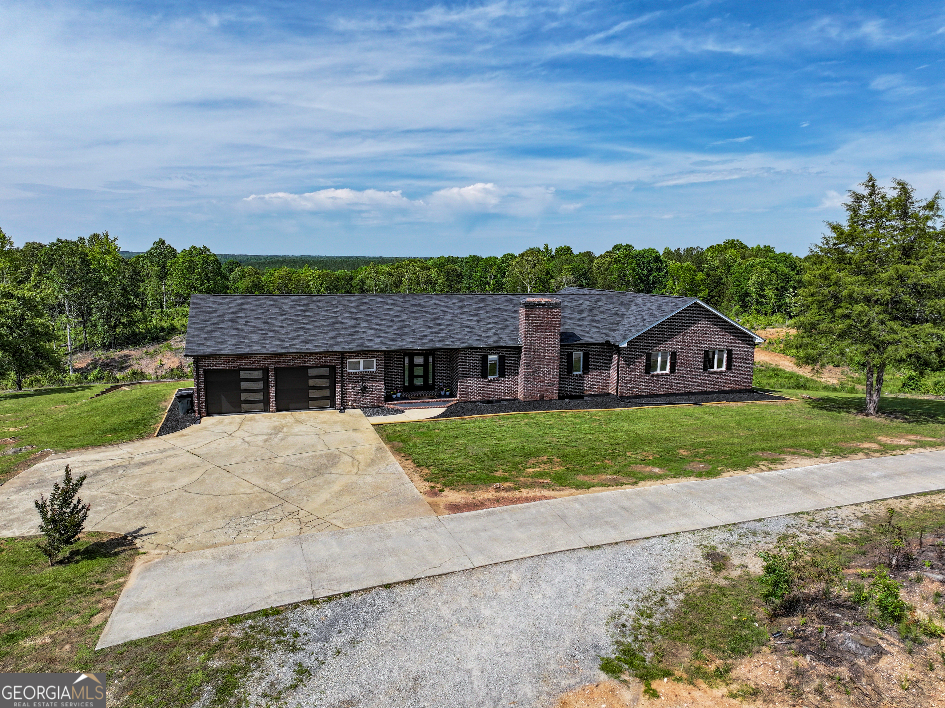 Welcome to 134 Roy Dean Road in Buchanan, Georgia - a spacious 3-bedroom, 4.5-bath, 4-sided brick home offering approximately 4,300 sq ft of living space on 8 beautiful acres. This home features a large open living room with expansive views and a cozy wood-burning fireplace, perfect for family gatherings or relaxing evenings. The master suite includes separate his-and-hers bathrooms for added comfort and privacy. A laundry/mudroom with exterior access adds functional convenience, and the generous back porch provides an ideal space for outdoor entertaining or enjoying peaceful country mornings. The large, partially finished basement with its own exterior entry offers great potential for additional living or storage space. For hobbyists or those needing extra workspace, the property includes a 40x24 metal shop with two 14-foot roll-up doors allowing for easy drive-thru access. An additional 46+/- acres are available for those seeking even more room to expand or explore. Home is occupied - please do not disturb the owners. Showings by appointment only.