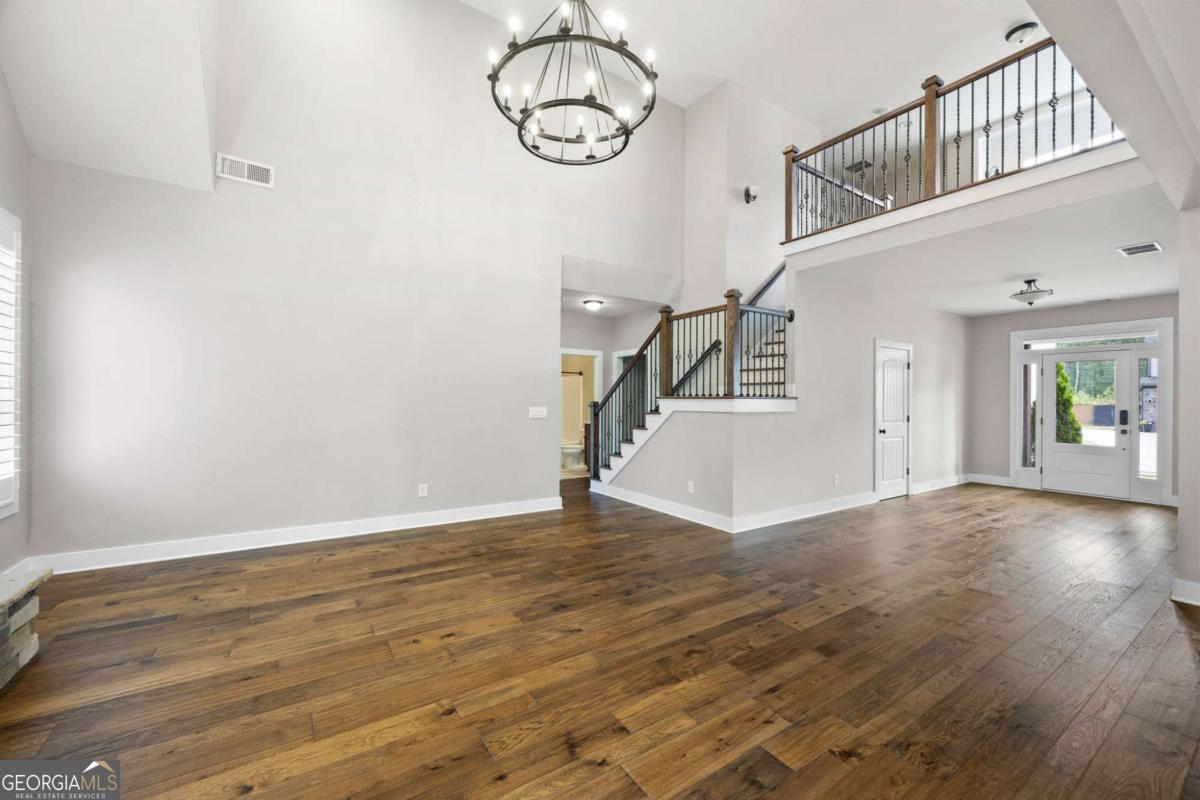 Welcome to this stunning 4-bedroom, 3-bath Craftsman-style home offering 2,707 sq. ft. of modern comfort and timeless charm. Situated on a large private lot, this open-concept design includes a convenient main-level bedroom and full bath, with the spacious master suite and two additional bedrooms upstairs. The home showcases all-new hardwood floors, plush carpet in the bedrooms, new stair railing, fresh interior paint, updated lighting throughout, and custom shutters. The gourmet kitchen features quartz countertops, a stone backsplash, farmhouse sink, professional under-cabinet task lighting, new dishwasher, faucet, and garbage disposal. The centerpiece of the living area has a 2 story ceiling that is absolutely breathtaking! The stackstone fireplace ties it all in and comes with a remote-controlled insert. Additional upgrades include a custom window seat with lots of strorage in the loft, a new insulated garage door with a two to one car conversion, a side parking pad for a third car, and smart home features offering remote control of locks, thermostat, and security. Enjoy the private covered patio overlooking the flat backyard, along with two large side yards-perfect for entertaining or relaxing. Located within walking distance to schools, just 10 minutes from downtown Cartersville, and close to the interstate. Residents enjoy an active HOA community with pool, tennis courts, and a playground. This move-in ready home combines modern upgrades with neighborhood convenience-don't miss it!
