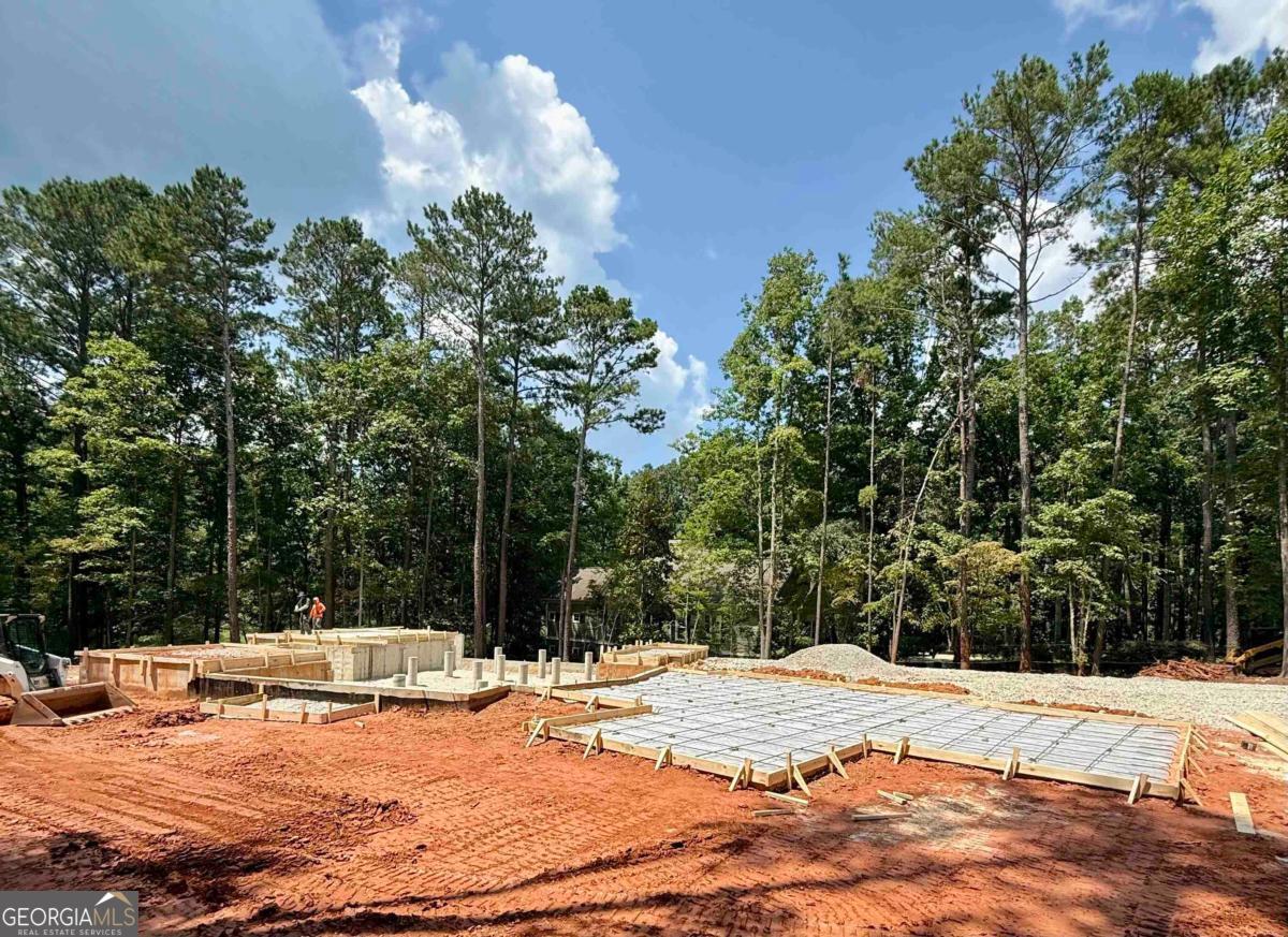 NEW Construction 4 Bedroom/4.5 Bath Custom Home on the National Golf Course at Reynolds Lake Oconee. Two Bedrooms and 2.5 Bathrooms on Main Level with an additional Living Area, Two Bedrooms and Two Full Bathrooms located on the Upper Level. Oversized 3-Car Garage with additional 10'x15' Storage Room off rear of Garage. Open concept with Large Kitchen and Island open to Vaulted Living Room with Stacked Stone Fireplace and Wood Ceiling Beams. Upgraded features including Pella Windows, Pella Double Front Doors, 10+ Ft. Ceilings on Main Level, 8 Ft. Solid Interior Doors, Spray-Foam Insulation, Hardwood and Tile Floors throughout Main Level, Custom Cabinets, Quartz Countertops, Upgraded Appliance Package, Whole House Water Softener System, Fully screened and covered Rear Porch with Full Stacked Stone Fireplace, Covered Grilling Porch and More. Centrally located in the neighborhood on a nice, level golf course lot. Seller is making available a Reynolds Lake Oconee Golf Membership. Estimated Completion in January 2026.