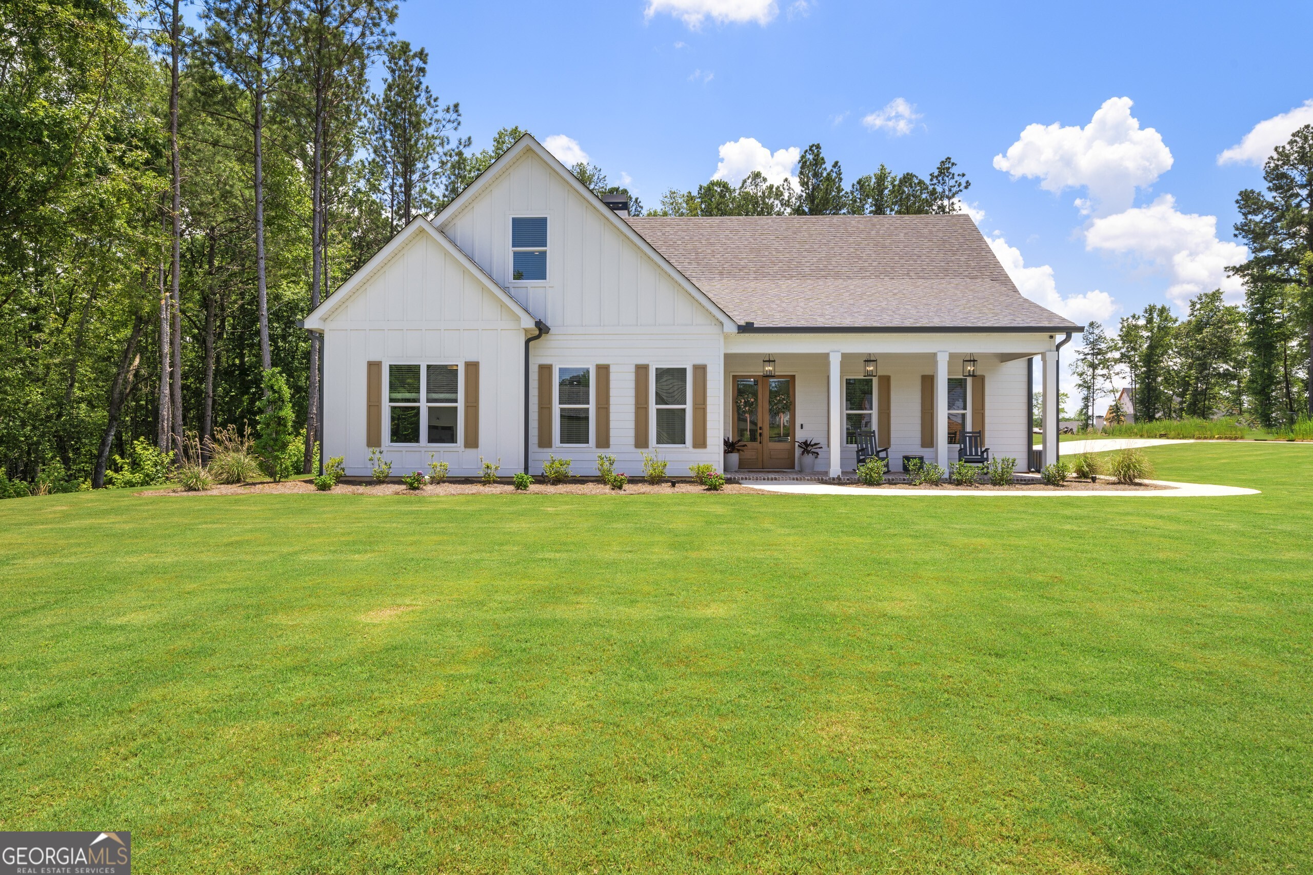Welcome to this gorgeous, light-filled home in the sought-after Northshore at Lake Redwine community. Truly better than new and loaded with thoughtful upgrades, this home is move-in ready with high-end finishes, functional design, and stylish touches throughout. From the moment you arrive, you'll notice the care and attention to detail. The charming front porch features a brick paver floor and warm tongue-and-groove wood ceiling, setting the tone for what's inside. Step through the double front doors into a cheerful foyer that opens into a spacious family room with built-in cabinets, floating wood shelves, fireplace, and a showstopping 12' beamed ceiling. A panoramic sliding glass door leads out to a covered patio complete with a fireplace, brick pavers, and wood ceiling ideal for grilling, relaxing, or enjoying your morning coffee. The kitchen is a true centerpiece: perfect for both cooking and gathering. It features stainless steel appliances including a luxury Thor 48" range with griddle and double oven, a pot filler, solid slab quartz backsplash, large island with farmhouse sink, soft-close cabinets and drawers, pull-out spice rack and pull-out utensil storage, and even extra cabinets on the back of the island. An elegantly arched doorway leads to a butler's pantry, walk-in pantry, and a large laundry room with sink, ample storage, quartz counter, and a hanging rod. The dining area is spacious enough for a large table and ideal for hosting. The main-level primary suite offers a private retreat with a spa-like bath featuring dual sinks, hair tool pull-out storage, a standalone tub, and a tiled walk-in shower with built-in niche. The custom walk-in closet is generously sized and well organized. Two additional bedrooms are also on the main floor-one with a private ensuite and the other adjacent to a full bath with tiled walk-in shower. Upstairs, you'll find a spacious loft, an additional bedroom and full bathroom, and an oversized theater room equipped with built-in speakers, projector, and screen-perfect for movie nights or game days. Additional highlights include a 3-car garage and an energy-efficient tankless water heater. Northshore at Lake Redwine is an amenity-rich neighborhood centered around a 300-acre lake where you can swim, fish, kayak, or cruise on an electric boat. Community features also include a pool with splash pad, tennis/pickleball courts, and playground making it easy to enjoy the outdoors and connect with neighbors.