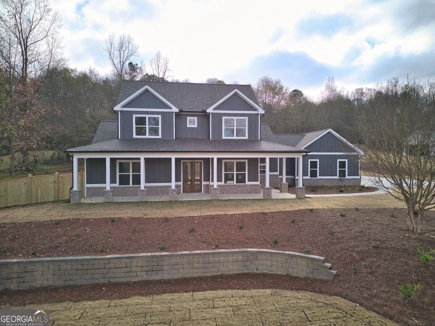 YEAR END INVENTORY OFFER 16K BUILDER PAID RATE BUY DOWN OR ANYWAY YOU WANT IT WITH PREFERRED LENDER, DONT MISS OUT BUILDERS AMAZING REDUCTION PRICE. PREFERRED LENDER is also offering additional loan saving of up to 2% of qualifying loan amounts and buyers! Enjoy the perfect blend of luxury and privacy in this exquisite wrap around covered porch Farmhouse. Picturesque and professionally landscaped 2.365 acre lot in highly sought-after Braselton location. This open concept retreat features 10-foot ceilings, 8-foot doors, designer trim, coffer and tray ceilings, hardwood floors throughout main level and upstairs hall, luxury lighting and plumbing fixtures, custom designed tile work, stone counters, custom cabinets, benches, built in closets and pantry, fireplaces and so much more. The custom chef kitchen offers an oversized island, undermount and glass cabinet lighting, custom backsplashes, stainless THOR Appliances to include: 48-inch LP gas range w/double oven, drawer microwave, custom hood, dishwasher and refrigerator, custom shelved walk in pantry. The spacious owners suite features access to patio and a large on-suite bath with oversized shower, soaking tub, H/H vanities and large custom-built walk-in closet. Main floor laundry room with cabinets and sink. Study/bedroom with access to full bath, storage closet and mud bench complete the main level. Make your way upstairs to three spacious bedrooms, one of which features on suite bath. Outdoor living features a wood burning fireplace and ceiling fans, three car garage with openers, extended parking, security flood lights, professional landscaping and plenty of room for future pool, workshop and outdoor living, Fully fenced backyard inside property lin, crossed fenced front yard. Solidly constructed this beautiful farmhouse is built impress the most discerning buyers. Centrally located in within a few miles of I85, 985, Hwy 129, Hwy 53, Hwy 124 and Hwy 60. HOME IS READY FOR CO CONSTRUCTION IS COMPLETE!
