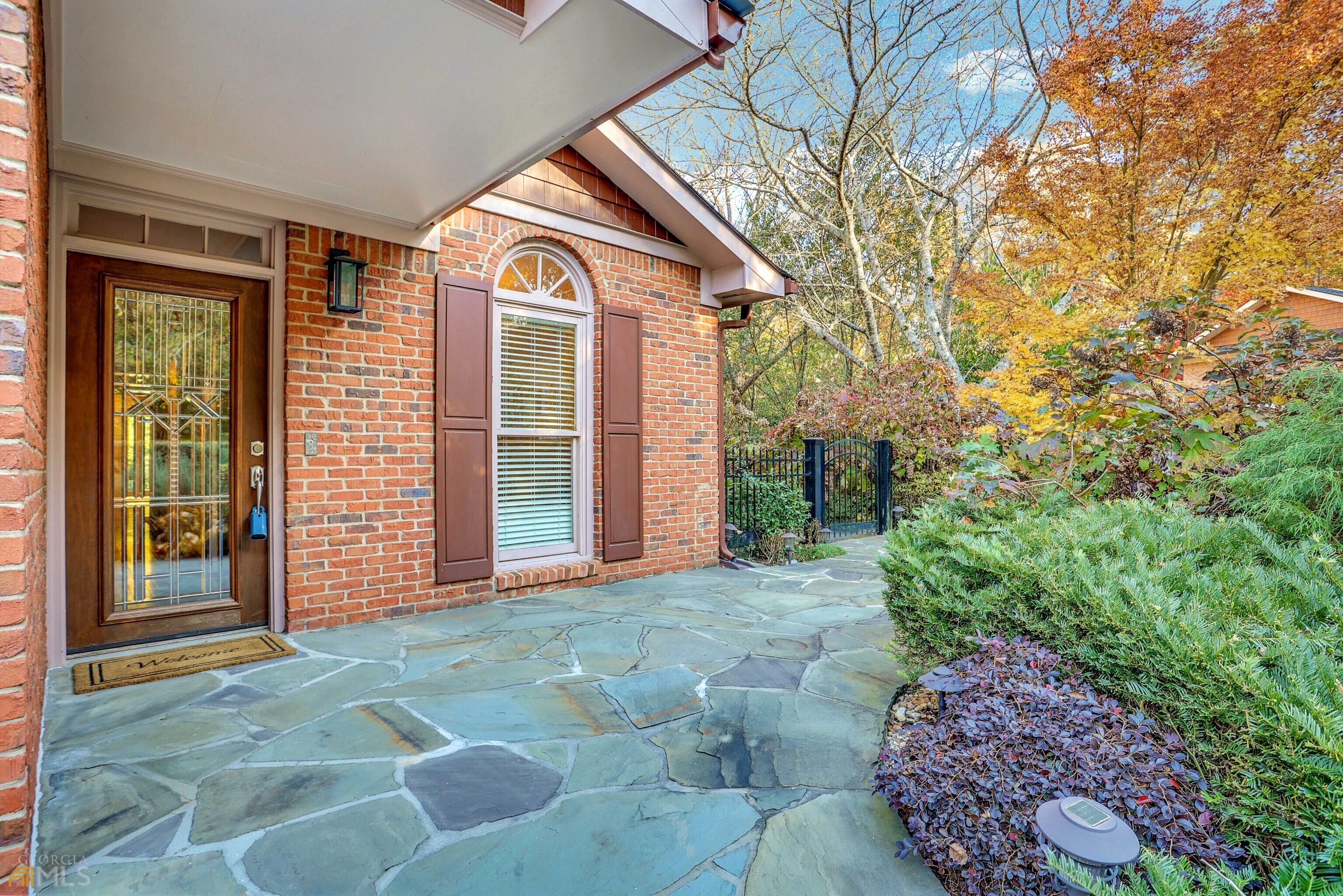 Nestled on a quiet courtyard surrounded by lush landscaping, this brick ranch offers main floor living at its finest. Set in central Brookhaven, this unique home is extraordinary inside and out with high-end finishes plus serene outdoor spaces. Gleaming hardwood floors welcome you inside, and flow throughout. The chef of the house will appreciate the gourmet kitchen boasting ceiling height cabinets, granite countertops, travertine backsplash, and stainless steel appliances, and leads outside to the patio, where you will love sipping your morning coffee watching the sunset. On cooler days, gather in the living room around the fireplace and let the natural light flood in through the expansive floor to ceiling windows featuring a separate doorway to the private, wooded backyard. Find retreat in the primary ensuite with elegant tray ceilings, custom shelving in the spacious walk-in closet, and a luxurious bathroom with separate shower and spa tub and provides separate access to the deck. Attached two car garage offers plenty of additional storage space for your outdoor gear and seasonal belongings. Well situated to all the services and conveniences you could need, including well-loved restaurants, the shops and boutiques of Town Brookhaven, and Oglethorpe University, plus easy access to downtown Atlanta and Buckhead via highways or the Brookhaven-Oglethorpe Marta Station.