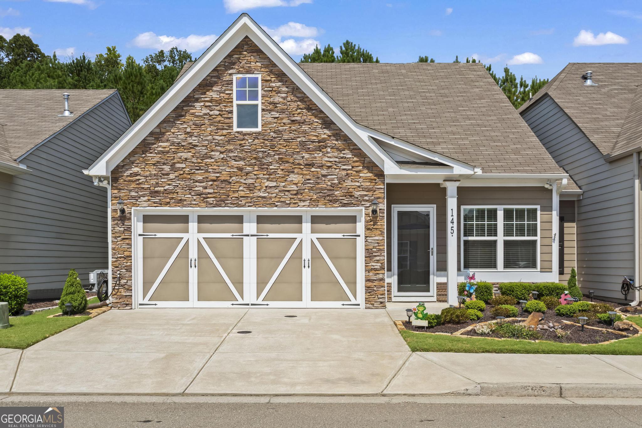 Welcome to the very best of The Villages at River Pointe-one of the area's most sought-after 55+ active adult communities! This beautifully maintained home blends comfort, style, and convenience. Step inside to an inviting open-concept design with gleaming hardwood floors throughout the main living area. A light-filled sunroom-style nook with custom built-ins is the perfect spot for morning coffee, overlooking the professionally landscaped patio, fully fenced backyard, and peaceful views. The chef's kitchen features timeless white cabinetry, granite countertops, recessed lighting, and a spacious island-all open to the living and dining areas for effortless entertaining and everyday ease. The main-level owner's suite is a true retreat with a tray ceiling, spa-like ensuite bath with walk-in shower, dual granite vanities, and generous walk-in and linen closets. Upstairs, two spacious bedrooms and a full bath offer flexible space for guests, an office, or hobbies. Beyond the home, you'll love the vibrant lifestyle The Villages at River Pointe offers-an active clubhouse, planned social events, and easy access to shopping, dining, and North Georgia's best attractions. Enjoy low-maintenance living in a welcoming community designed for connection, relaxation, and fun!