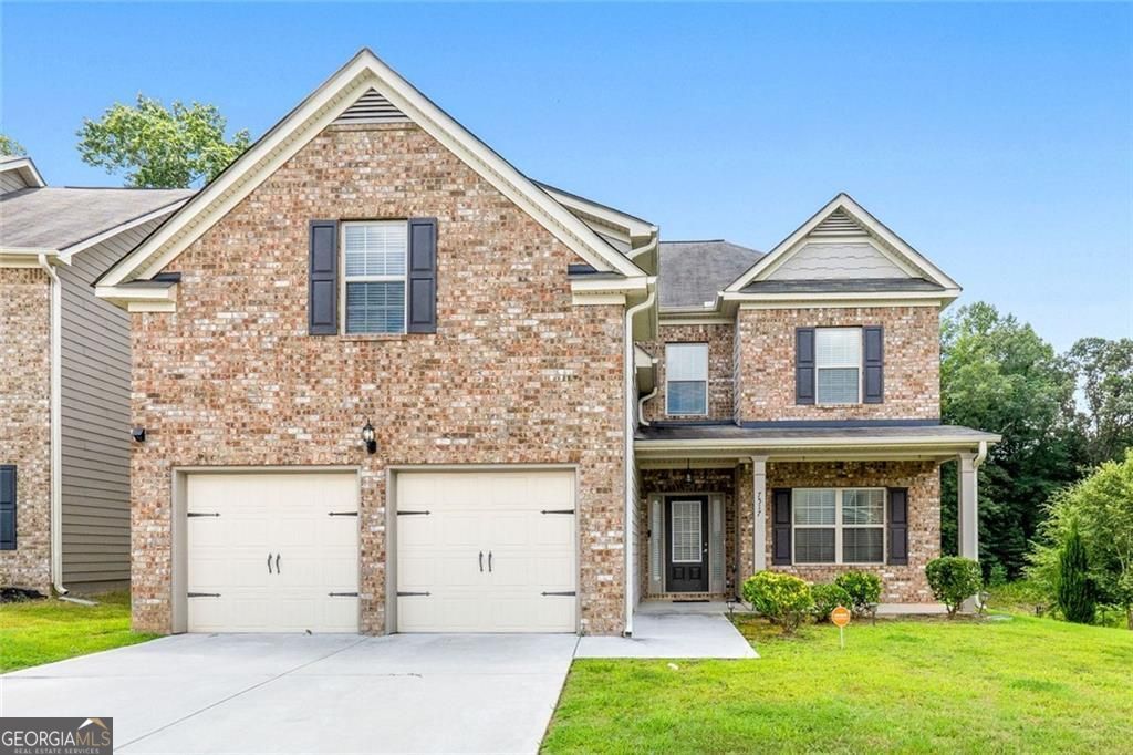 Welcome Home to Comfort, Style & Convenience! Step inside this beautifully maintained Thornton floor plan offering 5 spacious bedrooms and 3 full baths, perfectly designed for modern living. Priced to sell, last year, this house appraised for $387k. Built in 2020 with a classic brick front and a welcoming rocking-chair front porch that is perfect for your morning cup of coffee/tea or simply to relax in, this home has the curb appeal and comfort you've been looking for. The main level features luxury vinyl plank flooring throughout, combining elegance with easy maintenance. Real wood stairs lead to the second floor, adding warmth and character. Hosting in-laws or guests? The main-level bedroom offers privacy and convenience. You'll love the open-concept kitchen with recessed lighting, an abundance of cabinetry, a generous walk-in pantry, and seamless flow into the oversized family room with a cozy gas fireplace that's ideal for entertaining or relaxing. The separate formal dining room with coffered ceilings sets the stage for unforgettable dinners and celebrations, allowing more room for seating. A practical mudroom off the 2-car garage keeps things tidy and organized. Upstairs, retreat to your large owners suite with room to unwind in the sitting area. Need a playroom or a man cave? One of the oversized secondary bedrooms is the perfect flex space, big enough for a pool table, game room, or media lounge. Enjoy the outdoors year-round on the covered patio, which can easily be screened in for added comfort and privacy. All of this, and it's just 19 minutes to Hartsfield-Jackson Airport and under 30 minutes to downtown Atlanta to catch a show or have dinner, a commuter's dream! This home checks all the boxes for space, functionality, and location, all at an unbeatable price. Schedule your showing today, before it is gone tomorrow!