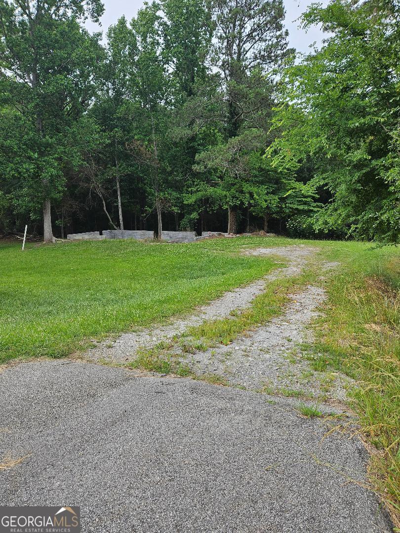 3.72 Acres with a partial basement, septic tank, county water meter and a well. The land is partially sloped with a level area for construction of a new home. It is open and wooded with mature trees. It is located outside of the city limits of Cedartown and minutes to Cave Spring. The address location is aka Hwy 100.