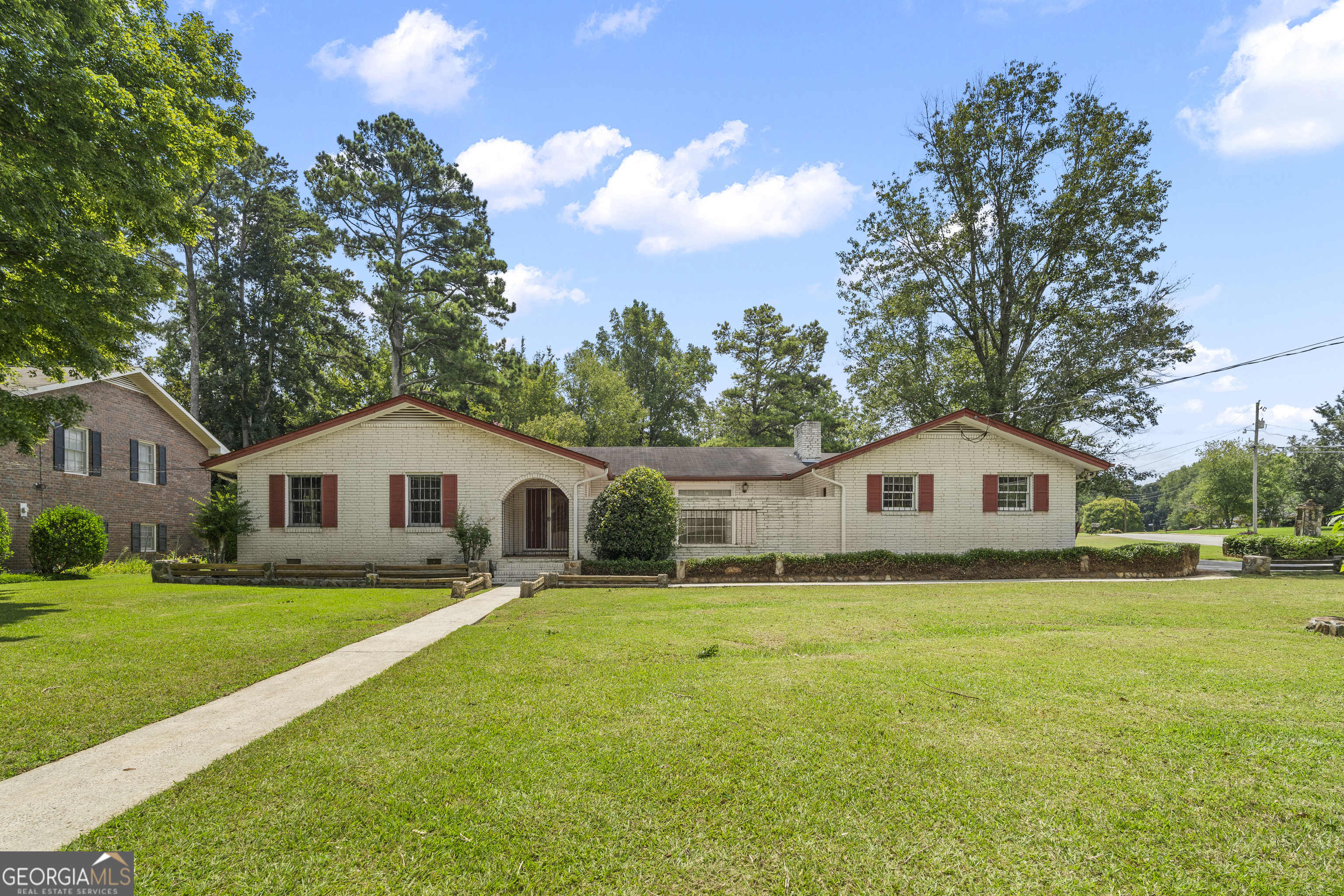 Great fixer-upper opportunity in Griffin! This 3-bed, 2-bath brick home on a corner lot is full of potential and just needs a little love to really shine. The home is spacious with plenty of indoor and outdoor living space. Inside, you'll find an entry foyer leading to the living room, a separate dining room, and a kitchen. There's also a family room with a stone fireplace centerpiece. The primary suite includes an ensuite bathroom, plus two additional bedrooms and another full bath. Other highlights include a screened-covered porch, an uncovered deck, a small gated courtyard, a 2-car carport, a utility room, and a laundry room.