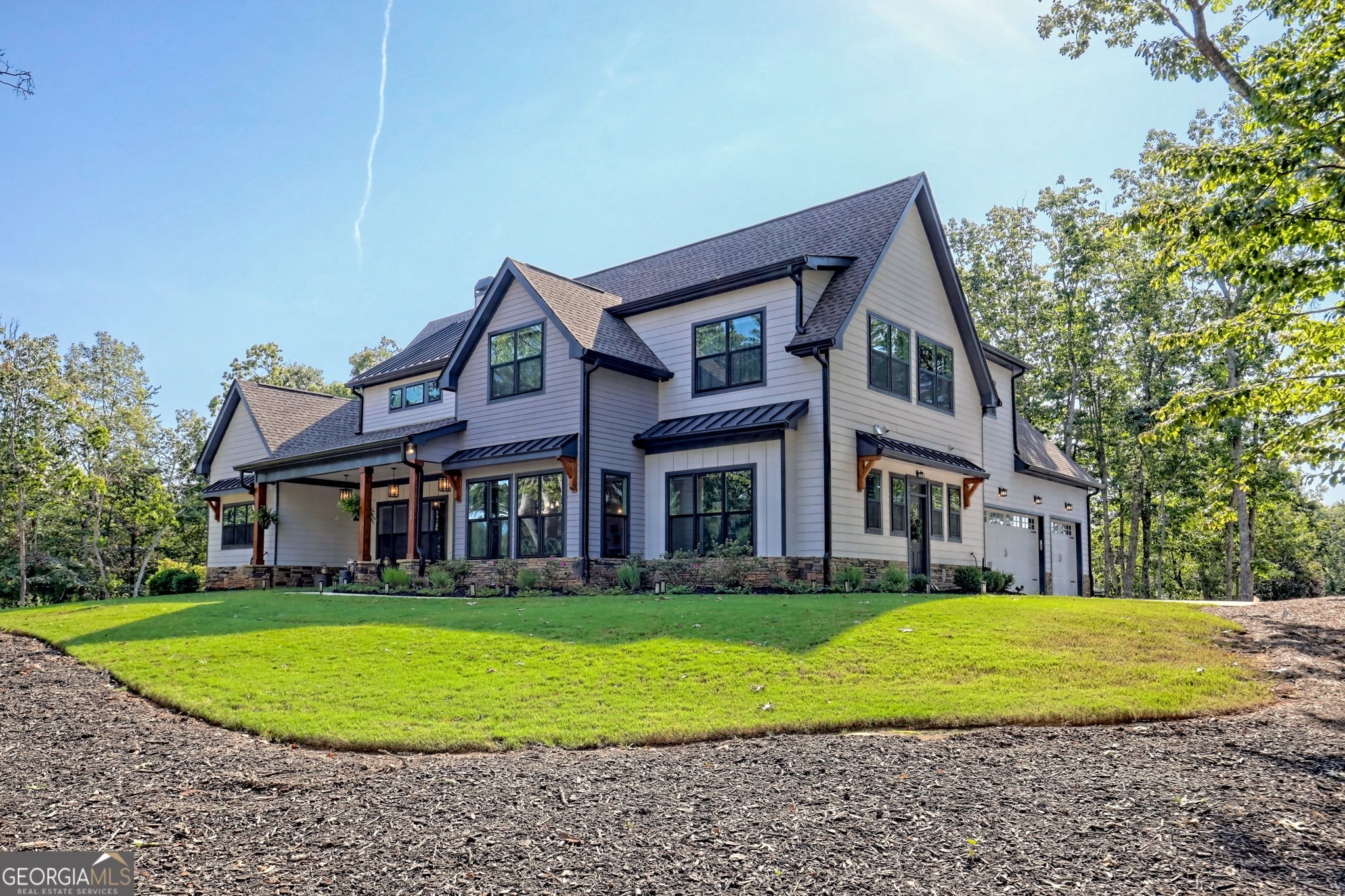 Luxury Modern Farmhouse in The Orchard - Fully Furnished & Move-In Ready-Tucked at the end of a quiet cul-de-sac on just over an acre, this modern farmhouse offers a refined balance of elegance, comfort, and thoughtful upgrades. From the moment you arrive, the impressive curb appeal sets the tone with a timeless mix of stone, shingle, and lap siding, accented by wood timbers and a standing-seam metal roof. Inside, natural light fills the open floor plan, enhanced by automated remote blinds for convenience and privacy. The home offers five bedrooms and three- and-a-half bathrooms, including a main-level primary suite with a beautifully customized walk-in closet. The gourmet kitchen flows seamlessly into the dining and living areas, with enhancements such as a pantry outfitted with wooden shelving, all new appliances and a custom-built office with rich cabinetry. Fresh paint, upgraded finishes, a spacious laundry room, and an oversized 3.5 car garage further elevate the home's livability. Upstairs, an additional built in office space, four generously sized bedrooms, and one oversized bonus room/theatre room plus 2 bathrooms-provide ample space for family and guests. Outdoor living has been elevated with a brand-new deck and hot tub, a fully equipped outdoor kitchen with grill and flat-top, professional landscaping with fresh mulch, and charming flower boxes. Every feature has been designed for comfort and ease. The property is offered fully furnished with high-end decor and furnishings, and also includes a whole-house water filtration system with pump for excellent pressure. An underground "Dog Guard" fencing system is already in place-just add collars. Located in The Orchard, Northeast Georgia's premier gated golf community, residents enjoy mountain views, lakes, apple orchards, and abundant wildlife, along with access to a private 18-hole golf course, driving range, clubhouse, pool, tennis, and pickleball. This home represents a rare opportunity to own a luxury move-in ready retreat in one of Georgia's most prestigious communities.
