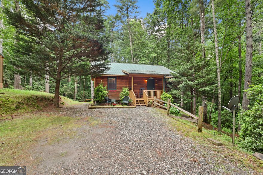 Welcome to "Knotty Pines" - your peaceful escape in the heart of the Northeast Georgia mountains! Tucked away on a serene, wooded lot in the charming Sautee Nacoochee community, this beautifully maintained cabin combines rustic charm with modern comforts. Surrounded by lush grass and towering trees, the property offers a private, natural setting that feels worlds away-yet is easily accessible with paved road access. Inside, you'll find warm wood finishes, soaring vaulted ceilings, and a cozy fireplace that creates the perfect ambiance for quiet nights or memorable weekend getaways. The open-concept layout seamlessly connects the living, dining, and kitchen spaces, giving the home a bright, airy feel. Recent upgrades include a new HVAC system for year-round comfort and lightning-fast Trailwave fiber internet-perfect for remote work or streaming. It will be sold fully furnished, making it move-in or rental ready from day one. Step outside to unwind on the spacious screened-in back porch or take a relaxing soak in the hot tub while enjoying the sights and sounds of the surrounding forest. Whether you're sipping your morning coffee or stargazing at night, the outdoor space is your personal retreat into nature. Zoned for short-term rental use, this cabin is not only a wonderful full-time home or vacation escape-it's also a fantastic investment opportunity. Buyers have 60 days from closing to transfer the rental permit into their name. This truly is a must-see property. Contact The Zach Garvey Team today to schedule your showing!