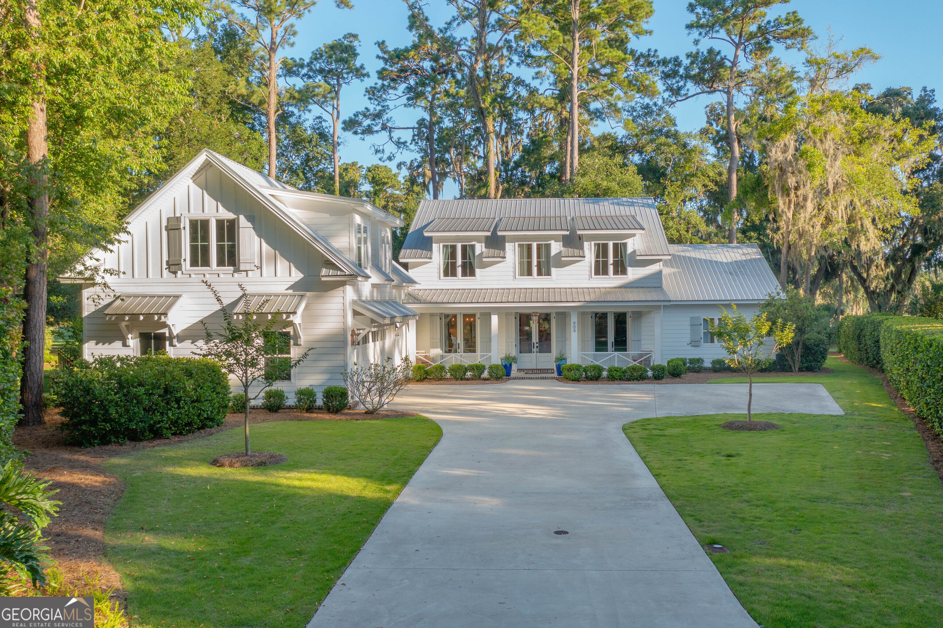 Tucked at the end of a quiet cul-de-sac in the gated coastal enclave of Hampton Plantation, this exceptional 2019 modern farmhouse pairs refined architectural design with the serenity of nature. Framed by ancient oaks and unfolding across a marsh front setting on the 11th hole of the King and Prince Golf Course, this home is more than just a residence-it is a sanctuary. A haven where privacy, elegance, and lifestyle come together in perfect balance. From the moment you enter, the light-filled layout welcomes you with a sense of calm-an open, curated design grounded by luxury LVP flooring, solid wood interior doors, and designer lighting throughout. The living spaces include a separate dining room for gathering and a large office that offers a quiet place to focus or reflect. The kitchen is the heart of the home-a true centerpiece where function meets elegance. Quartz countertops, a Cosmo gas range, soft-close cabinetry, farmhouse sink, generous pantry, under-counter microwave, and a charming coffee bar offer both beauty and efficiency, thoughtfully designed for everyday living and effortless entertaining. The open concept design incorporates kitchen, breakfast area, and living room, anchored by a gas-log fireplace. This heart of the home opens seamlessly to a screened porch that becomes a second living space-complete with a wood-burning fireplace and gas starter-framing marsh views that shift with the light and invite stillness as day fades to dusk. The main-level primary suite is a retreat within a retreat-elegant, serene, and designed with care. It features dual walk-in closets, double vanities, a soaking tub, water closet, and a beautifully finished shower. Upstairs, guests or family can enjoy three spacious bedrooms-one en suite and two sharing a Jack and Jill-plus a generous lounge-style living area with oversized windows that bring the outdoors inside. Above the garage, a 725-square-foot bonus room offers flexibility for a media room, gym, studio, or private guest hideaway. Practicality is elevated throughout the home with a generous laundry room and ample cabinetry designed for high-functioning daily use. You will also find tremendous storage throughout the home, including closets and built-ins that make organization both easy and elegant. The X flood zone provides peace of mind as well as substantial insurance savings. Every feature speaks to thoughtful craftsmanship-from the standing seam metal roof and impact-rated, energy-efficient windows to the tankless water heater, dual HVAC systems, and a 2.5-car garage with an enclosed outdoor shower. The fenced backyard is both private and inviting-a peaceful place for pets to roam or quiet mornings with coffee and birdsong. Here, nature is not just a backdrop, but part of the daily rhythm-deer grazing at dusk, egrets gliding across the marsh, and coastal breezes threading through the oaks. Yet, the home remains perfectly connected. Area amenities-including golf, tennis, pool, clubhouse, and Hampton Marina-are just a short ride away. And just a few miles south, the charm of island life awaits with access to beaches, boutique shopping, and beloved local dining-making this home both a quiet retreat and a gateway to everything that makes St. Simons so special. This is a turnkey, well-appointed home for those seeking a life of grace, ease, and meaning-a place to breathe, to gather, and to live surrounded by natural beauty. A place where every view is a gift, and every moment feels like home.