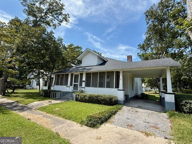 Charming Craftsman Bungalow on Spacious City Lot Welcome to this inviting 2-bedroom, 2-bathroom home situated on a large city lot with mature trees and plenty of green space. Featuring timeless character and modern updates, this home is perfect for those seeking both comfort and potential. Spacious Layout: Generous living and dining areas with tall ceilings, abundant natural light, and original architectural details including decorative fireplaces and wide trim work. Large Kitchen: Ample cabinet storage, expansive counter space, and room for a breakfast table or island to make it your own. Cozy Bedrooms: Comfortable rooms with large windows and ceiling fans. Updated Bathrooms: Practical, updated baths with modern fixtures and easy-care finishes. Outdoor Living: Enjoy a classic screened front porch, ideal for relaxing, plus a side yard shaded by mature trees. Accessibility: Back entry includes a wide ramp for convenience. Extra Storage: Detached storage building with metal roof provides plenty of room for tools, hobbies, or a workshop. Covered Parking: Side driveway with carport-style covered space. This home is full of potential-move in as-is, or update further to fit your style. Conveniently located near local shops, schools, and parks, it offers the perfect blend of charm, space, and opportunity.