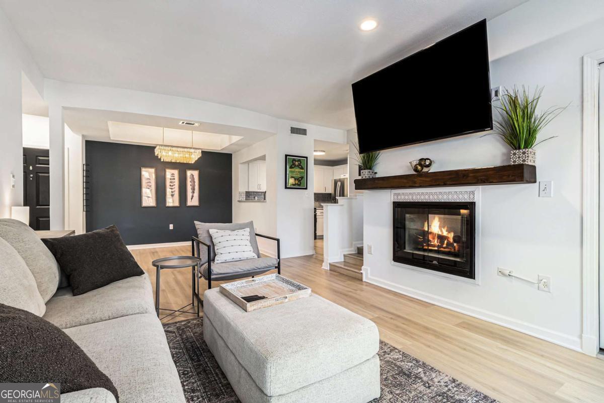 Stunning and beautifully appointed 1 bedroom, 1 bath home in an incredible intown Atlanta location. This charming residence welcomes you in with brand new LVP flooring, and a warm, cozy family room featuring a double sided fireplace that also enhances the adjoining office, study, or flex room, creating the perfect space for working from home, relaxing, or simply unwinding at the end of the day. The open concept dining and kitchen area is ideal for everyday living and entertaining, with white cabinetry, a gorgeous backsplash, beautiful countertops, and open views straight into the family room, so you never miss a moment. The spacious bedroom offers comfort and privacy, and the refreshed bathroom showcases a sleek frameless glass shower. All of this is set within a secure, gated community with amenities to enjoy, including a pool, clubhouse, fitness center, and dog walk areas. Everyday conveniences are right at your fingertips with Publix, Walgreens, and the Post Office just around the corner, plus you are only minutes from Piedmont Park, Fox Theatre, Ponce City Market, The Beltline, Central Park, fantastic restaurants, shopping, entertainment, universities, and major interstates, making this home the perfect blend of style, comfort, convenience, and city living. Just 5 minutes from GA Tech!