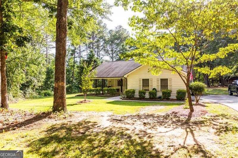 Welcome to 810 Northlake Circle, a well-maintained 3-bedroom, 2-bath home with an additional office/flex space, nestled on a quiet 1.9-acre lot in a peaceful Oxford neighborhood. Inside, you'll find luxury vinyl plank flooring throughout and an open-concept layout that seamlessly connects the kitchen, dining area, and living room. A wood-burning fireplace adds warmth and charm to the living space, making it ideal for both relaxing and entertaining. The primary suite features tray ceilings, a walk-in closet, and a spacious en-suite bath with a soaking tub, separate shower, and dual vanities. Two additional bedrooms and a flexible additional room offer space for guests, work, or hobbies. Enjoy outdoor living on the rocking chair front porch or back patio, and take advantage of the recently installed above-ground pool and included storage shed. The partially cleared 1.9-acre lot provides a rare blend of privacy and usable space. Move-in ready and full of features, this home offers the best of country living with modern comfort. Schedule your showing today and see all that 810 Northlake Circle has to offer.