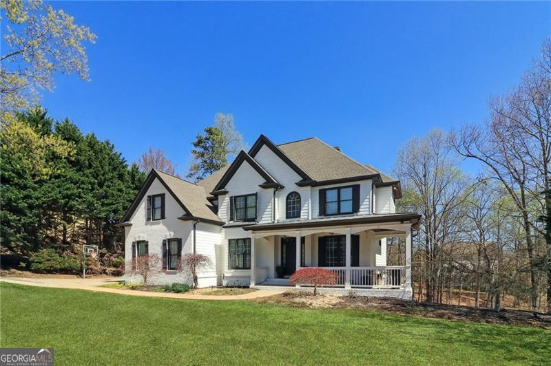 Welcome to 8525 Swiss Air Point, a stunning Craftsman-style home located just moments from Lake Lanier, with the Two-Mile Creek boat ramp less than a mile away. This exceptional residence features six bedrooms, five full bathrooms, a three-car garage, a home theater, a personal gym, and a game room. The grand two-story foyer leads to a private office and formal dining room, while the open-concept living area boasts a gas fireplace and flows into a gourmet kitchen with a double oven, gas range, island, and walk-in pantry. A main-level bedroom and full bath offer guest convenience. Upstairs, the primary suite includes a spa-like ensuite and an oversized walk-in closet, with three additional bedrooms and two bathrooms across the catwalk. The fully finished basement features a game room, a home gym, an additional bedroom with a fireplace, and a custom bathroom with a cave shower. Built-in speakers run throughout the game room and home gym, enhancing the entertainment experience. The state-of-the-art home theater is designed for an immersive experience, complete with reclining movie seats, built-in surround sound, and a custom-painted ceiling by the famous Lee Bivens. Outside, enjoy a wooded backyard with an expansive Trex deck and a private nature-view deck. This home offers luxury, comfort, and prime access to Lake Lanier - Schedule your private tour today!