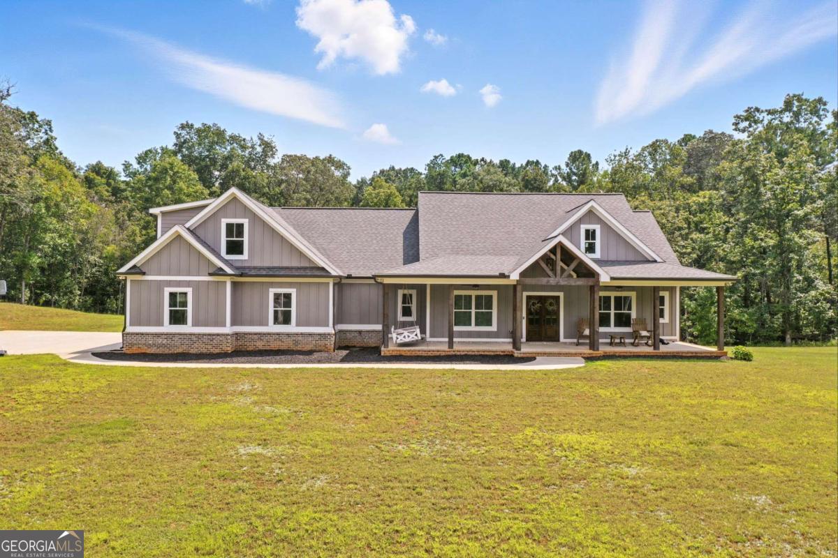 Custom-Built Private Estate on 8.49 Acres in Clayton Community of Canton, GA! Discover this stunning 2022 custom-built home offering 3,554 sq. ft. of living space, featuring 5 bedrooms, 2.5 bathrooms and a full unfinished basement ready for your personal touch. Tucked away at the end of a long gravel drive that transitions to concrete near the home, this property provides unmatched privacy and tranquility, while still being just minutes from shopping, dining, and I-575. Set on 8.49 acres, including 3 acres of open yard, there's endless room for recreation, gardening, or even adding a detached garage or workshop. The oversized two-car garage boasts tall doors for larger vehicles, while the exterior showcases durable fiber cement siding, fascia, and soffit for low-maintenance living. Step inside to an open floor plan with high-end finishes throughout. The vaulted great room and master suite create a grand, airy feel. The master retreat features a luxurious spa-like bath with a Jacuzzi tub, double-headed tile shower, and a large walk-in closet complete with shoe shelving and a hidden safe room. Additional highlights include hardwood flooring on the main level, tile in bathrooms, plush carpet in bedrooms, a spacious laundry room with sink and dog shower, and a tankless hot water heater. Enjoy outdoor living at its finest on the vaulted covered back deck with an adjoining open-air section-perfect for entertaining or simply taking in the serene surroundings. Located in the sought-after Clayton Community of Canton, this property offers the best of both worlds: peaceful seclusion with easy access to Riverstone Parkway, Downtown Canton, and beyond.
