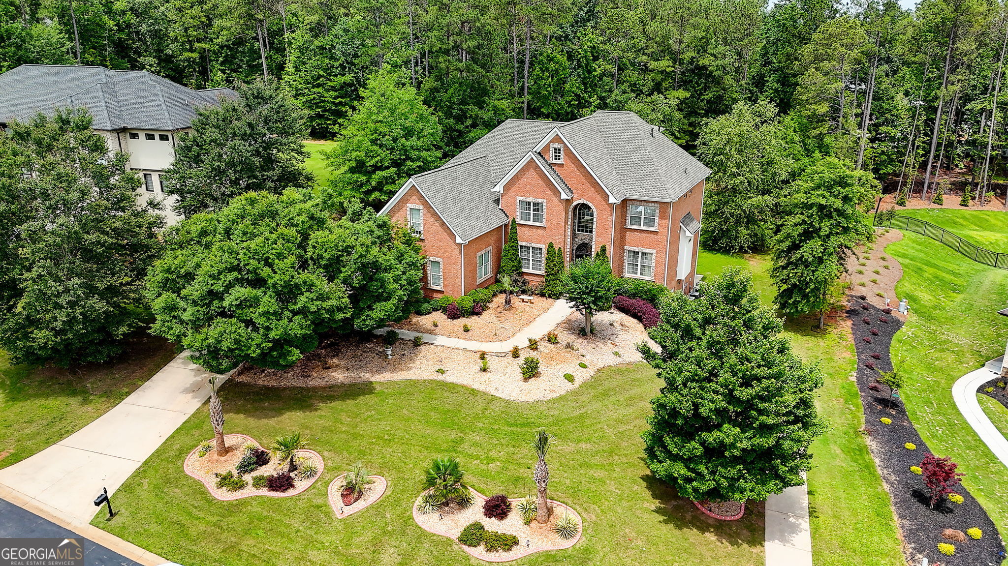 PRICE IMPROVEMENT - Welcome to 805 Cog Hill - Country Club Living at Its Finest! Nestled on over an acre in a quiet cul-de-sac within a prestigious gated Country Club community, this stately 4-sided brick estate offers luxury, space, and endless upgrades! Featuring 6 bedrooms and 7 full baths, this home is designed for refined living and grand entertaining across four finished levels. Step inside to soaring ceilings, new designer tile flooring, fresh interior paint, and custom craftsmanship throughout. The main level impresses with a formal living room, a banquet-sized dining room, and a two-story family room with bowed floor-to-ceiling windows, built-in bookcases, and a striking fireplace. Full bedroom and bath on main add flexibility for guests or multigenerational living. The gourmet kitchen is a chef's dream with Viking appliances, BOSCH refrigerator, double wall ovens, built-in microwave, and a spacious breakfast area that opens to the extended deck featuring a remote-controlled oversized awning, staircase to the yard, and a separate outdoor music system. Upstairs, the luxurious primary suite boasts a sitting room, trey ceilings, abundant natural light, and an oversized custom closet with WARDROBE STEAMER SYSTEM INCLUDED. The spa-like primary bath features dual vanities, a deep soaking air-jetted jacuzzi tub, and a separate tiled shower. Laundry room located off primary suite. Each of the three secondary bedrooms upstairs has its own private ensuite bath, and the 4th level loft includes a full bath - ideal for guests, work, or play. The fully finished basement continues the wow factor with a second kitchen featuring high-end Viking appliances, pot filler, ice-maker, and a massive island - perfect for entertaining. Enjoy the open layout, fireplace, custom room addition with MURPHY BED INCLUDED, a theater room with EQUIPMENT INCLUDED and exercise room with glass mirror doors. BONUS:BRAND NEW ROOF, 6 mounted TV's SONO MUSIC SYSTEM on main level, WASHER/DRYER and ALL KITCHEN APPLIANCES (BOTH LEVELS) are INCLUDED! Enjoy peace of mind with a brand-new roof, irrigation system, and the convenience of a 3-car side-entry garage. Resort style living with 27 holes of golf on Tom Fazio design courses, upscale clubhouse, dining, Tennis, Pickleball, swimming, events and more. Eagles Landing Country Club is less than 30 minutes to downtown Atlanta and the Atlanta airport. This home truly has it all - elegance, space, privacy, and unmatched upgrades. Schedule your private tour and experience the lifestyle at 805 Cog Hill!