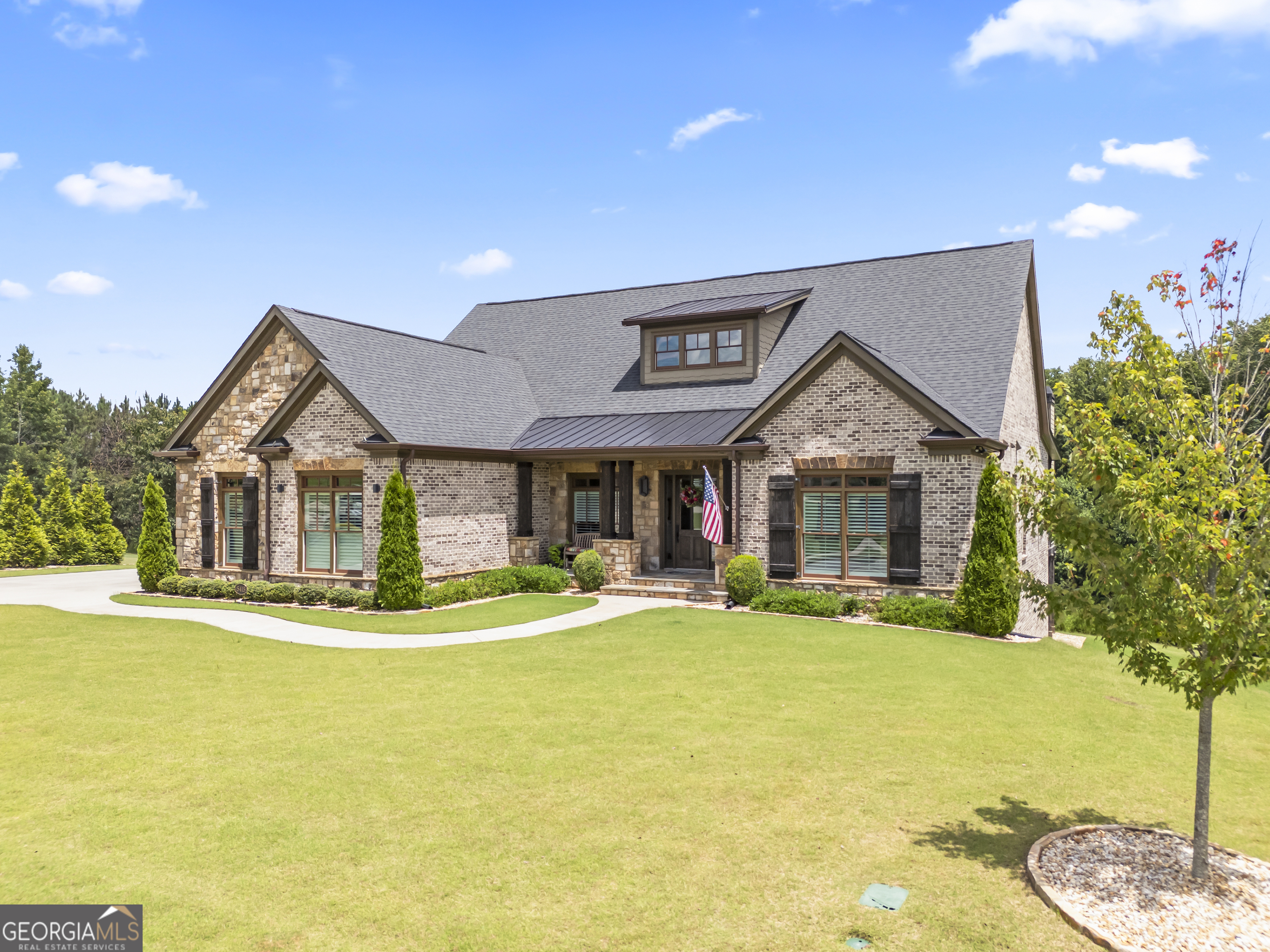 Custom Luxury Living in the Top-Rated Buford City School District Welcome to 5415 Falls Landing Drive, nestled in the highly sought-after Reserve at Big Creek Subdivision. Located in Hall County and zoned for the #1-rated Buford City Schools, this one-of-a-kind custom-built home offers the perfect blend of luxury, functionality, and convenience. Built in 2022 and thoughtfully designed with every upgrade in mind, this 5,610 sq. ft. four-sided brick home sits on an expansive 1+ acre lot and features an impressive 4-car attached garage. Step inside to soaring ceilings, rich hardwood floors throughout, and an open-concept layout ideal for modern living. The chef's kitchen is a showstopper with high-end appliances, an oversized entertaining island, wine fridge, and custom finishes throughout. Flow seamlessly into the large dining area and elegant living room featuring a fireplace with custom built-ins. Enjoy Georgia evenings on the screened-in patio with its own fireplace, perfect for hosting or relaxing with your morning coffee. The main-level primary suite is a true retreat, offering a spa-inspired bathroom with a soaking tub, separate shower, double vanities, and a massive walk-in closet. All additional bedrooms on the main level are generously sized and offer great functionality. The finished basement is a dream for entertaining and extended living - complete with a media room, billiards area, custom bar, and a private guest suite with full bath. A separate entrance provides flexibility and privacy, while a dedicated storage area is perfect for gardening, landscaping equipment, or a workshop.This smart home also features low-voltage exterior lighting and integrated home automation systems, offering both comfort and convenience.Don't miss your opportunity to own this rare gem in a prime location with access to top schools, spacious luxury living, and every upgrade already in place.