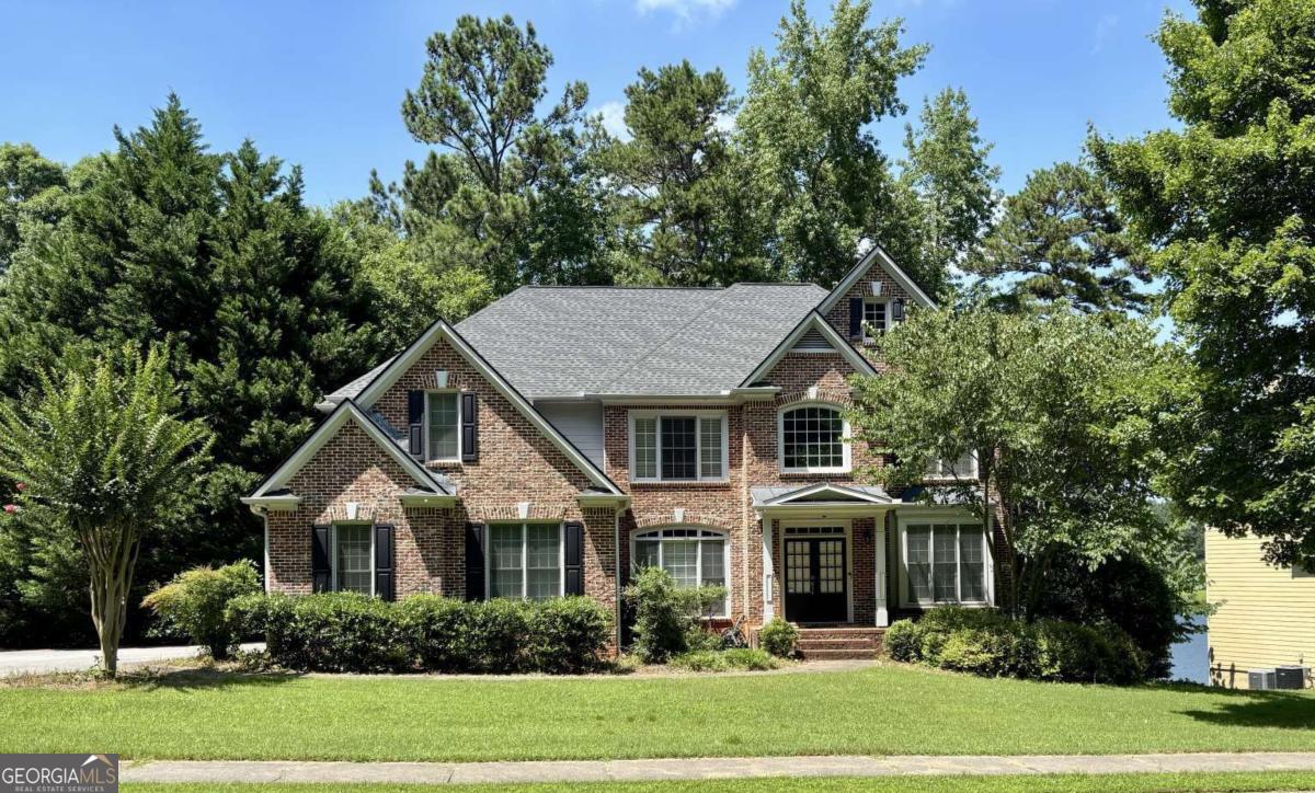 Well maintained 5 bedroom 4 full bath one owner lakeside home. Two story great room with wall of windows overlooking the lake with gas log fireplace. Guest bedroom on the main level, home office conveniently located off kitchen perfect for working at home. Island in kitchen with vegetable sink and quartz stone countertops with hardwood cabinets. Walk in pantry and laundry room. Crown molding and heavy trim throughout. Recently painted and roof updated with architectural shingles. Large owners bedroom with sitting area, tray ceiling and French doors to owners bath with center jacuzzi tub , tv niche, window seat and spacious walk in closet with additional hidden storage. Two secondary bedrooms share Jack n Jill bath. Last bedroom currently used as office has a dedicated bath and walk in closet. High ceilings in all upstairs bedrooms. Private wooded lakefront lot in a wooded park like setting near the end of a cul de sac. Located in swim/tennis community with several pools numerous tennis courts, pickle ball, playgrounds, clubhouses and other amenities surrounding a 140 acre lake. Only minutes from Stone Mountain Park main entrance.