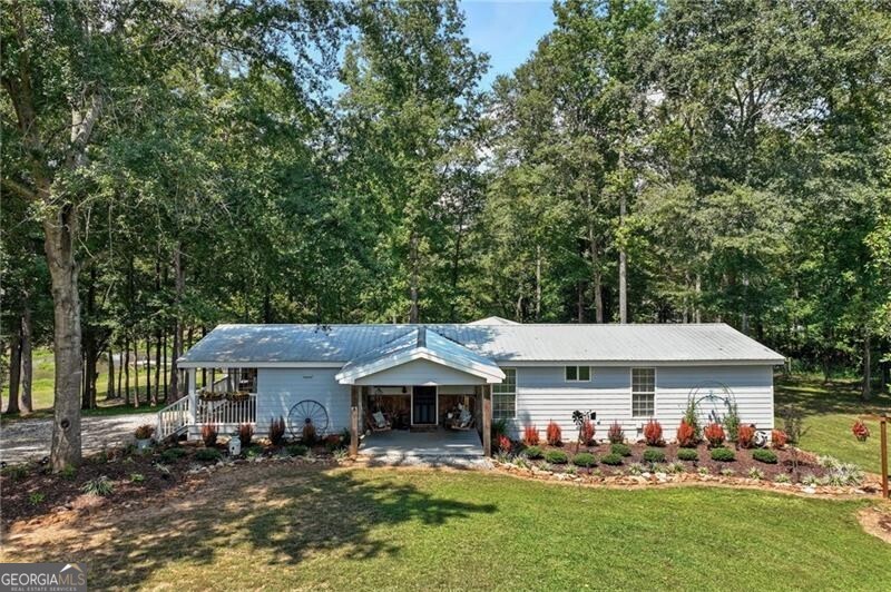 Discover the perfect blend of country charm and modern convenience with this beautifully remodeled Manufactured home set on a permanent foundation. Nestled on 26 acres with 200+ Feet of Hudson River Frontage, this property offers privacy, space, and endless possibilities-all just minutes from downtown Commerce and convenient to I-85. Currently operating as a working mini-farm, the property is fully fenced and features multiple barns and outbuildings, a detached garage, and a 4-stall pole barn ideal for large campers, boats, or farm equipment. A natural pond adds to the serene landscape, while a custom outdoor fire pit or the Hand built pier on the pond makes the perfect gathering spot for family and friends. Animal lovers will appreciate the opportunity to continue the legacy of this farm: while livestock is not included, the seller is willing to leave behind two cherished donkeys (a bonded mother and son pair) for the right buyer. Whether you're seeking a private homestead, hobby farm, or a retreat with abundant space for recreation and storage, this property delivers. With gated drive, gorgeous landscape, and river frontage, it's truly a rare find.