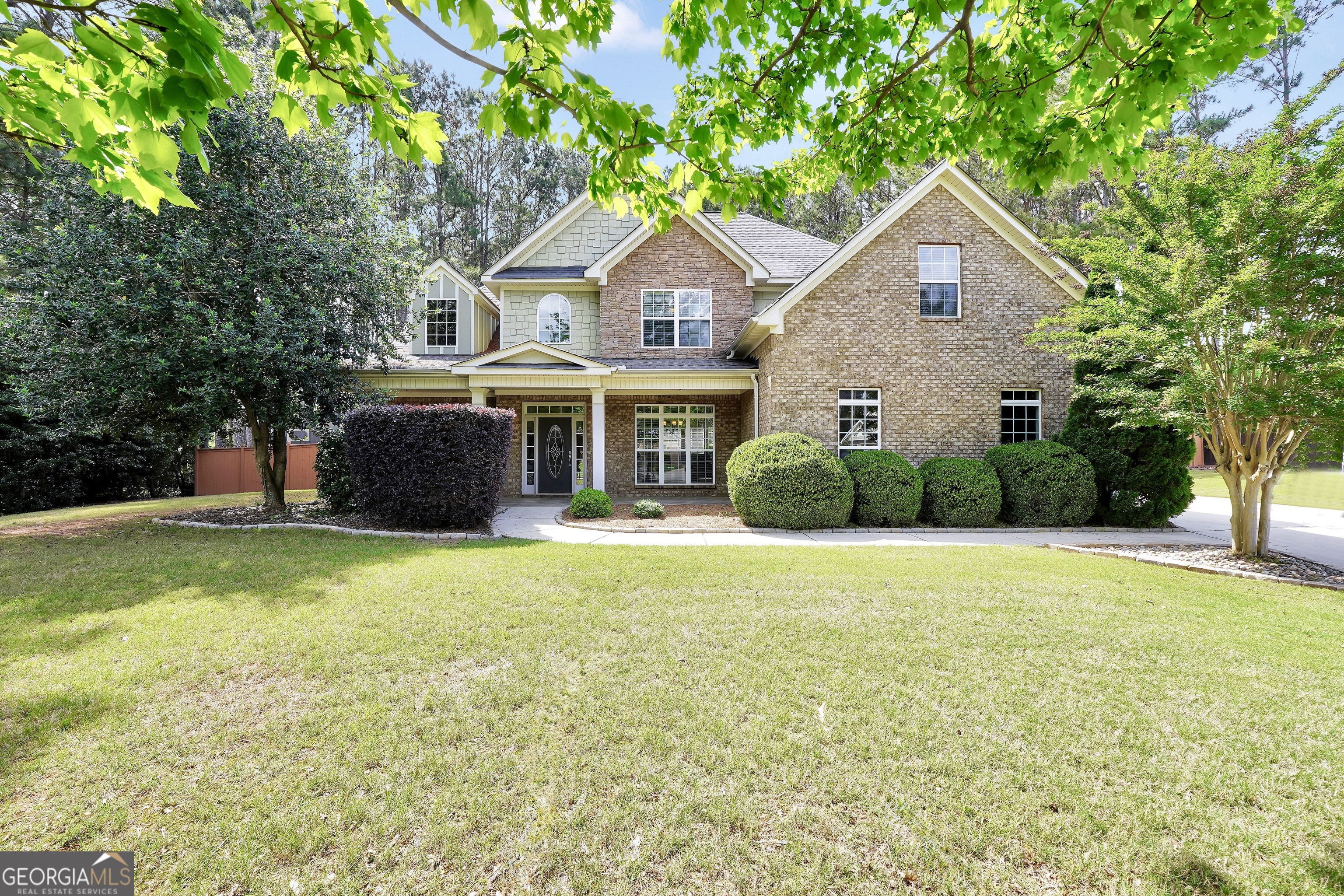Stunning 4 Bedroom, 2.5 Bath All-Brick Home with Custom Outdoor Living - Impeccably Maintained! From the moment you arrive, this beautifully maintained all-brick home welcomes you with a spacious rocking chair front porch and impressive two-story foyer. Inside, you'll be captivated by the gleaming hardwood floors, soaring 18.5' ceilings, and floor-to-ceiling windows that flood the open-concept living and dining areas with natural light. The kitchen is a chef's dream with granite countertops, stainless steel appliances, and a breakfast bar perfect for gatherings. The main-level oversized master suite includes a cozy sitting area, and the spa-like master bath boasts a dual vanity, soaker tub, and a tile shower with glass enclosure. Upstairs offers three additional spacious bedrooms and a full bath, connected by a catwalk overlooking the grand living area. Step outside to enjoy your private custom stone patio, 12' x 16' deck with gazebo, and fenced backyard oasis - perfect for relaxing or entertaining. Upgrades and maintenance include a newer hot water heater, new HVAC ductwork, and updated valves on the 3-zone system. This home offers timeless beauty, modern upgrades, and peace of mind. Don't miss your chance to own this showstopper!