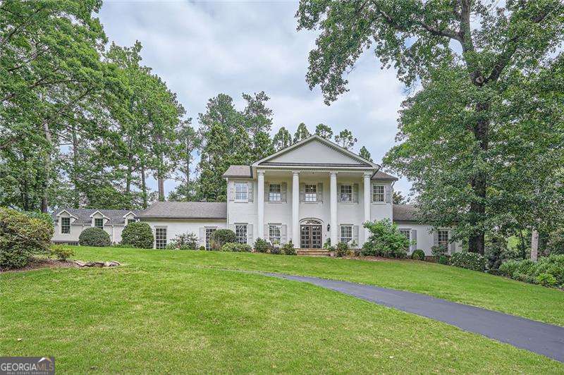 Set on a beautifully manicured 3/4-acre lot in East Cobb's premier Atlanta Country Club, this fully renovated luxury estate features classic four-sides brick construction and offers a rare blend of timeless architecture and modern sophistication. Boasting 6 spacious bedrooms and 5 designer bathrooms, this home is perfectly tailored for both refined living and grand entertaining. Inside, you'll find hardwood floors and plantation shutters throughout, setting an elegant tone in every room. The stunning new gourmet kitchen is equipped with stainless appliances, custom cabinetry, and an oversized island-seamlessly opening to the expansive family room filled with natural light. Just off the kitchen, a walk-in pantry/scullery offers additional prep and storage space and features its own full-sized refrigerator, perfect for effortless entertaining. The primary suite is conveniently located on the main level, offering a serene retreat with a spa-inspired bath and generous walk-in closets. Each secondary bedroom is well-appointed with upscale finishes, ensuring comfort and privacy for family and guests. The home also features an oversized, newly renovated laundry room with extensive cabinetry and workspace. Also on the main level, a brand-new full bathroom provides convenient access from both the kitchen and pool area, ideal for guests enjoying the outdoor amenities. Downstairs, the terrace level is both versatile and functional, featuring the perfect movie room, a large guest suite with a private bathroom, and a fully equipped home gym. This level includes its own private driveway and entrance, offering added flexibility and privacy for long-term guests or multi-generational living. Step outside into your private backyard retreat, complete with a resort-style gunite pool, mature landscaping, and multiple entertaining areas. A standout feature is the newly constructed detached 3-car garage with a luxurious carriage apartment above, ideal for extended family, guests, or a private office. Located in the award-winning Sope Creek, Dickerson, and Walton school district-and just minutes from championship golf, fine dining, and upscale shopping-this extraordinary home offers unmatched luxury, thoughtful design, and timeless curb appeal in one of Atlanta's most prestigious communities.