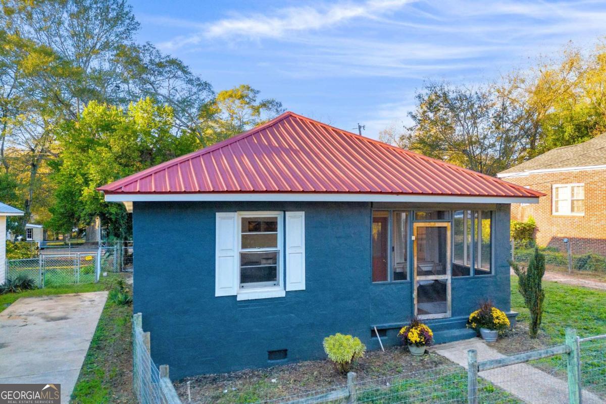 Motivated sellers!! This charming 1950s cottage, nestled just off Hancock, offers the perfect mix of vintage charm and modern upgrades. Ideal for a turnkey rental investment or a cozy in-town residence, the home is perfectly situated for convenience, with quick access to Milledge Avenue, Downtown Athens, UGA, and major highways. The home features three bedrooms and two bathrooms, with stylish tile and luxury vinyl flooring throughout. Enter through the front door into a bright living room with large windows that flood the space with natural light and lead out to a screened-in porch perfect for enjoying the outdoors in comfort. To the right of the living room, the first bedroom connects to a second bedroom, and both share a beautifully updated full bathroom with new flooring, lighting, and a sleek vanity. The heart of the home is a cozy dining or keeping room, conveniently located just off the galley-style kitchen. This kitchen is a dream with granite countertops, freshly painted cabinetry, and stainless steel appliances blending vintage style with modern functionality. A tasteful barn door leads from the kitchen to the second full bathroom and the laundry area, which also includes a stack-able washer/dryer. The third bedroom, which could also function as a secondary living space, offers added versatility and direct access to the rear patio. Other notable features include a durable metal roof, low-maintenance concrete exterior, and all public utilities. This well-maintained home is the perfect balance of charm and convenience in a highly sought-after location.