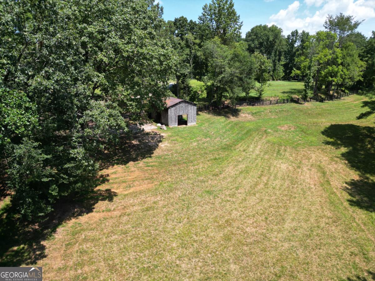 Incredible opportunity to own property in Milton with the space to build an exquisite estate; whether that be equestrian, recreational or a gentleman's farm. This property zoned AG is at the end of one of Milton's few and coveted gravel county roads, where horse farms dominate. Rolling pastures and open hardwoods provide multiple homesites for those that want out in the open or in the shade. A creek on the property line gives you access to year around water. If you are looking for a property on a quiet street away from the sounds of traffic, then this is the property for you. If you want additional acreage, more is available that is adjacent to this. Less than 5 minutes to the Birmingham Publix and 7 Acre bar and restaurant and 20 minutes to downtown Alpharetta, provide close and easy luxury shopping while feeling rural.