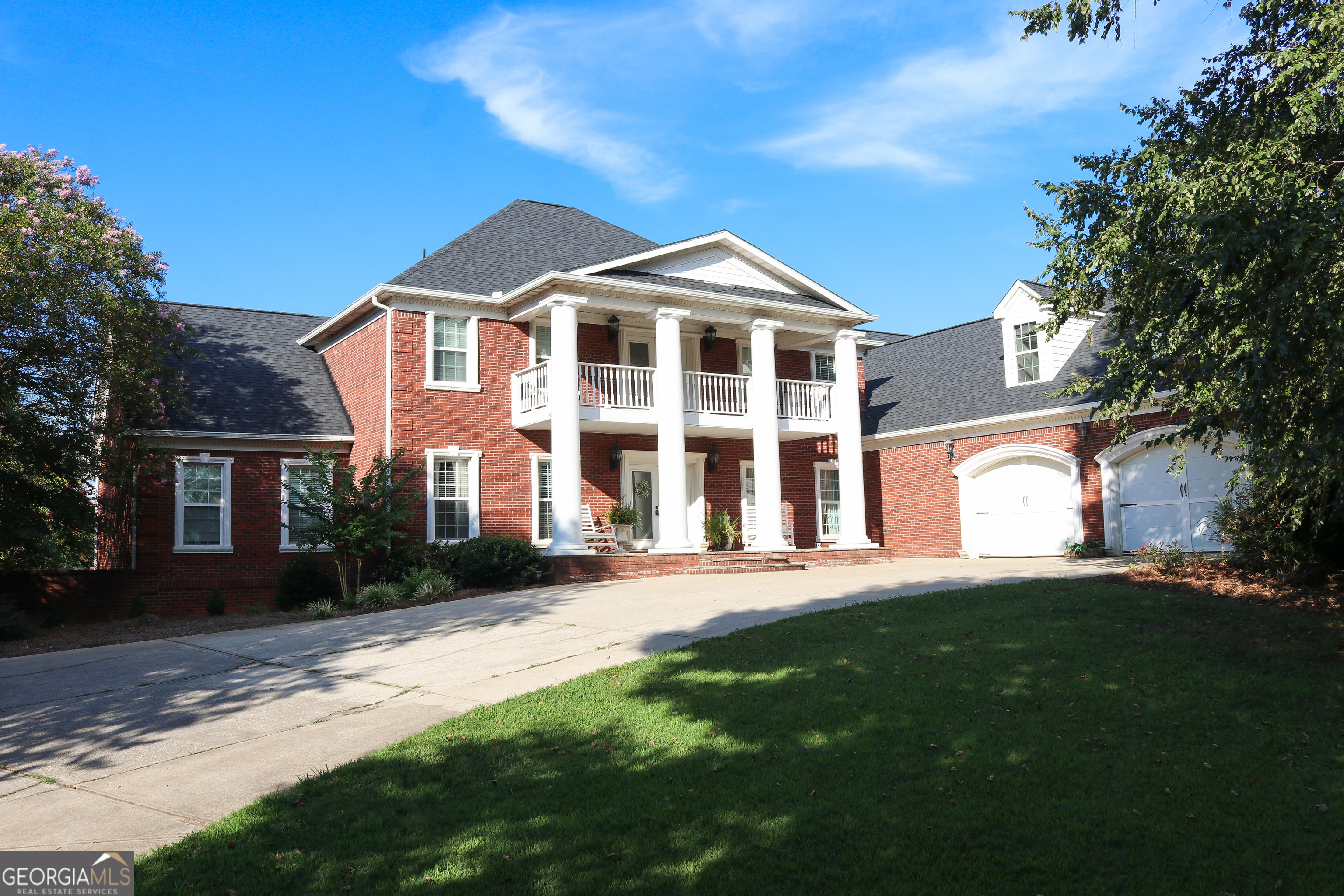 This stunning 63.18-acre estate near Madison offers a rare blend of luxury, privacy, and outdoor adventure just 6 miles from downtown. The four-sided brick home is expansive and elegant, featuring a grand two-story foyer with chandelier and open staircase, spacious family room with fireplace and hardwood floors, and a gourmet kitchen, perfect for entertaining, with ample cabinetry and countertops, a fireplace, and walk-in pantry. The Master suite is in the left wing of the home and showcases dual vanities, each a shower and a tub, a walk-in closet, and one of several attic spaces. Also on the main level, you will find a guest bedroom with full bath, a mudroom + laundry with coffee bar and dual washer/dryer hookups. There is a lovely partially covered deck overlooking the pond (stocked with bream and bass!) that can be accessed from both the den and kitchen. The upstairs is made up of 3 bedrooms, 2 full baths, 2 bonus rooms, and a large family area. In the basement, there are 2 full baths, a second full kitchen, family/TV room, and storage rooms - making this space ideal for a mother-in-law suite if needed. The basement opens to a fenced backyard with a cement inground pool. The grounds contain around 20 acres of pasture with two large barns, multiple varieties of fruit trees, and pecans. In the back of the property, you will find just over 30 acres of mixed hardwoods and pines with 3 well-spaced food plots, and sightings of deer and turkey. There is a solid road system throughout the woods allowing you easy access to get around. This is a must-see property if you are in the market for a stunning estate and looking for abundant wildlife, seeking a spot to raise livestock and/or for recreation. 4 miles from interstate 20 and highway 441. Call High Point Real Estate Group today to see this special place.