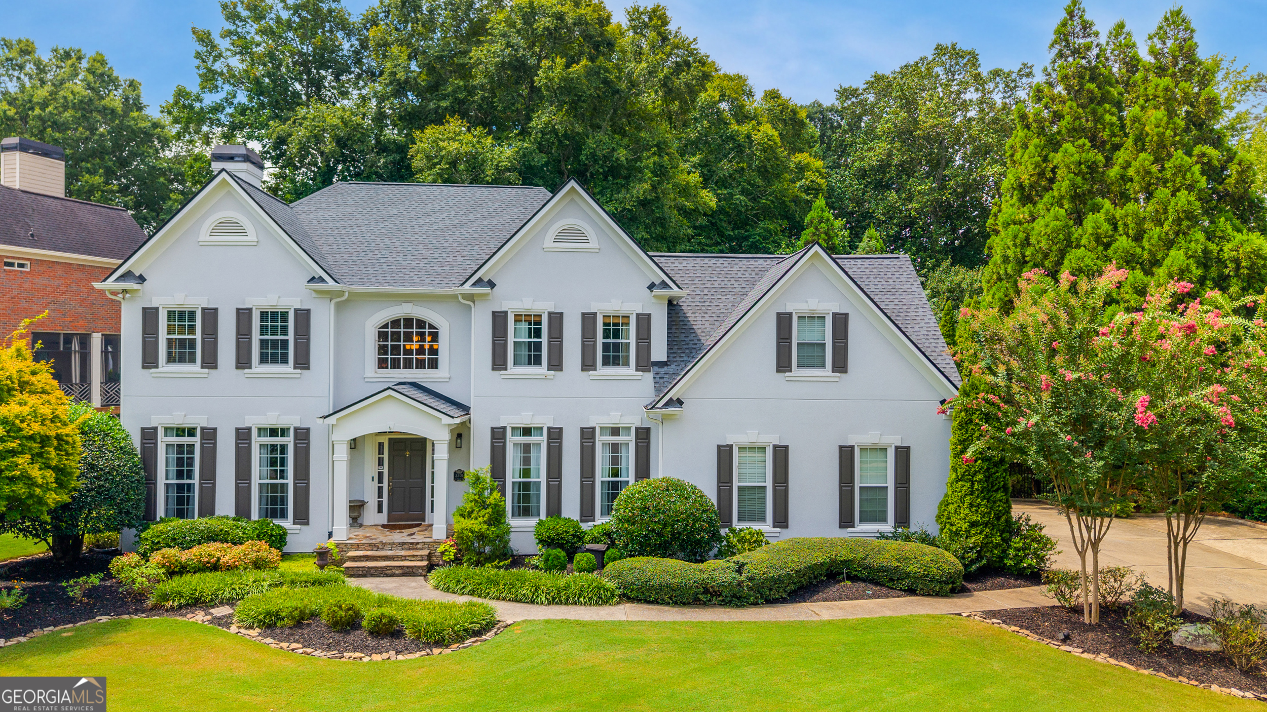 Discover this stunning 5BR/3.5BA home in Easthampton, East Cobb's premier swim/tennis community zoned for the highly acclaimed Walton High School, Dodgen Middle School, and Mt. Bethel Elementary. Perfectly positioned on a flat large corner lot, this home offers a private outdoor oasis featuring a saltwater pool, hot tub, cascading waterfall, and a unique multi-level chipping and putting green, your very own retreat for relaxation and entertaining. Enjoy seamless indoor-outdoor living with a screened deck featuring a built-in gas grill, a second covered dining deck, and a beautifully landscaped backyard with plenty of space to relax or play. (Adds approximately 700sf to the home with the outdoor living). Inside, the home boasts newly refinished hardwood floors, high ceilings with crown molding, and a two-story foyer. The fireside family room with custom built-ins flows effortlessly into the updated eat-in kitchen and separate dining room. The kitchen features white cabinetry, granite countertops, stainless steel appliances, gas cooktop and a sunny breakfast nook with featuring plantation shutters. Upstairs, the oversized primary suite is a luxurious escape with a spa-style bath, whirlpool tub, separate shower, dual vanities, and two walk-in closets. Three secondary bedrooms-one an oversized spacious bonus room-offer comfort and flexibility. The newly finished terrace level features an additional full bedroom and bath, a game room with a custom bar, and space for a media room, gym, or office-perfect for guests or entertaining. All this, just a short walk to Easthampton's resort-style amenities: clubhouse, pool, tennis courts, lake, dock, fitness center, playground, and year-round social events. This home is the perfect blend of luxury, location, and lifestyle located walking distance to The Avenues of East Cobb-schedule your showing today!
