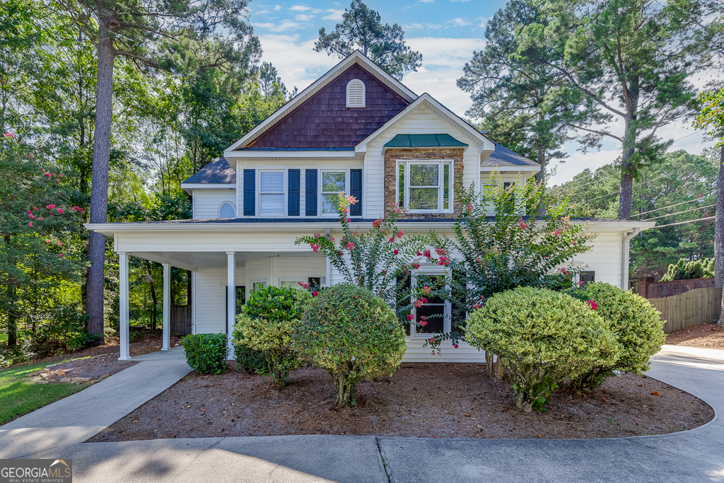 Located in the Magnolia Place community in Lawrenceville, this beautifully maintained 4-bedroom, 2.5-bath home offers comfort, convenience, and thoughtful updates throughout. The home sits on a level lot with a level driveway and features a two-car side entry garage for easy access. A charming front patio welcomes you into the main living space, where an eat-in kitchen boasts white cabinetry, stone countertops, stainless steel appliances, a built-in desk, and a clear view into the cozy family room with a fireplace perfect for everyday living and entertaining. Upstairs, all four bedrooms provide ample space, including a spacious primary suite with an ensuite bathroom featuring double vanities, a separate soaking tub, and a walk-in shower. Additional highlights include updated light fixtures, a finished storage area under the stairs, and a whole-house water filtration system. The backyard is fully fenced for privacy and includes a patio ideal for outdoor gatherings. Conveniently located close to Highway 316 and just minutes from vibrant downtown Lawrenceville, this home blends style, functionality, and accessibility in one desirable package.