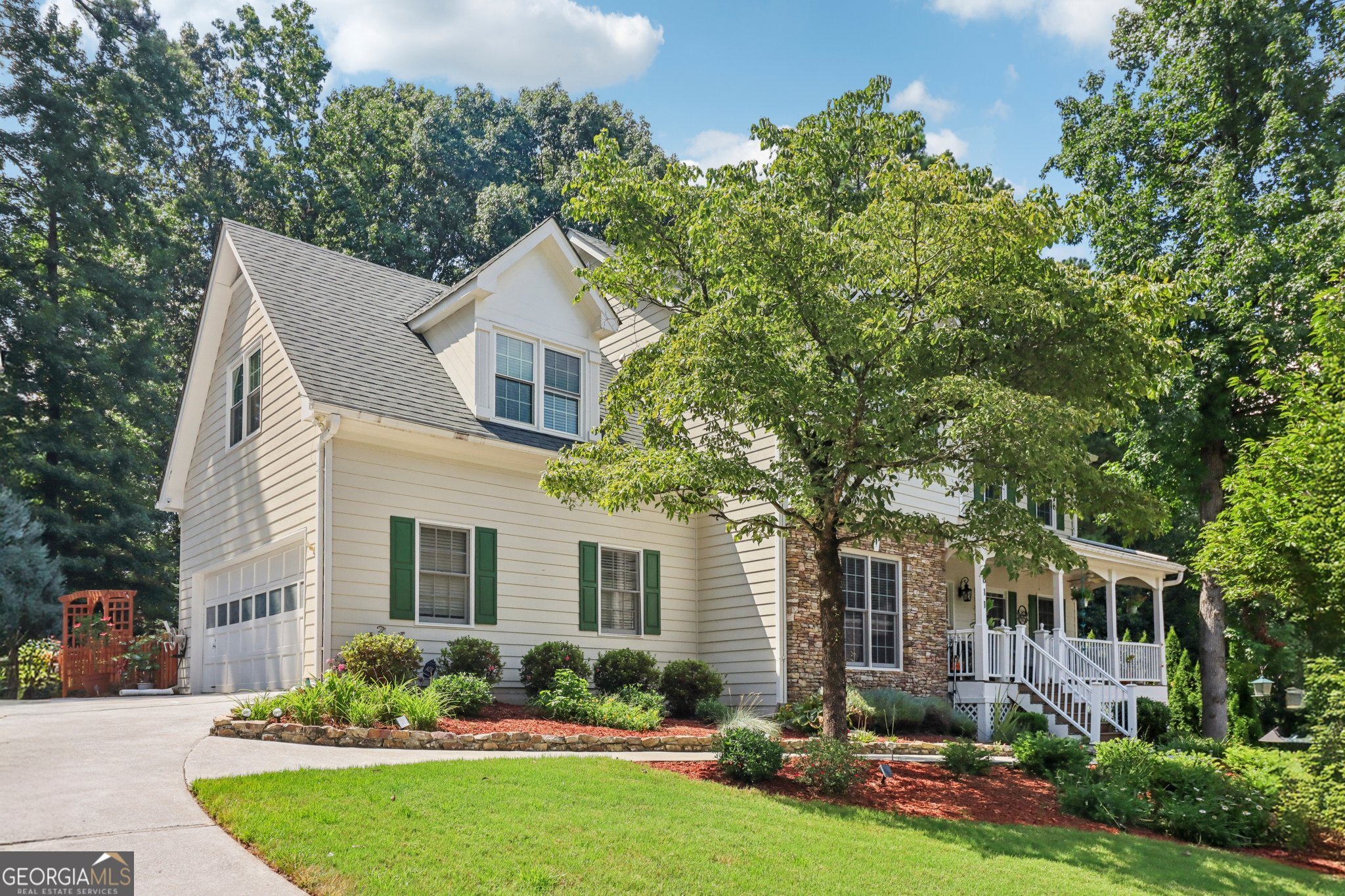 Flowers Crossing at the Mill - Brookwood School District! Tucked away on a quiet cul-de-sac in the highly sought-after Flowers Crossing at the Mill community, this beautifully maintained 5-bedroom, 2.5-bath home is a must-see. From the moment you arrive, you're welcomed by a charming front porch-perfect for unwinding with a good book or enjoying a peaceful evening breeze. Step inside to discover an expansive main level with oversized living and dining spaces ideal for entertaining. The white kitchen shines with granite countertops, stainless steel appliances, and plenty of cabinet space. Upstairs, you'll find generously sized secondary bedrooms and a spacious primary suite with a large ensuite bath. The partially finished basement offers a versatile bonus room and an additional bedroom-great for guests, a home office, or teen retreat. Out back, the professionally landscaped, fenced-in yard features a full irrigation system and provides a beautiful, private setting for outdoor living. Located in a swim/tennis community with access to top-rated Brookwood schools, this home is super clean, move-in ready, and loaded with updates.