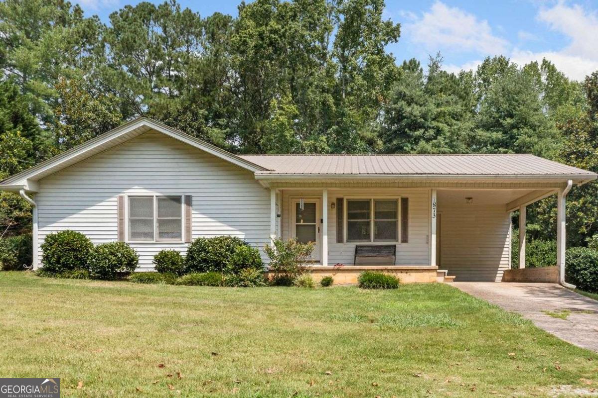 Charming 3-Bedroom Ranch Home on a Private 1-Acre Lot! Welcome home to this 3-bedroom ranch-style home nestled on a peaceful 1-acre lot. Tucked away in a quiet, wooded setting, this home offers privacy while still being just minutes from local restaurants, shopping, and everyday conveniences. Step inside to find a spacious and functional kitchen with ample cabinet space and a cozy dining area. The home features three comfortable bedrooms, ideal for family living, guests, or a home office. Enjoy relaxing on the covered front porch or entertain in your expansive backyard surrounded by mature trees-perfect for gardening, pets, or simply enjoying the outdoors. Additional highlights include a covered carport, large storage closets, and low-maintenance vinyl siding and metal roof. A concrete driveway and large storage building add convenience and value. This price point is a rare find for the area. Whether you're a first-time buyer, downsizing, or seeking a quiet retreat close to town, this property offers the best of both worlds. Don't miss this opportunity to own a slice of tranquility with modern convenience nearby!