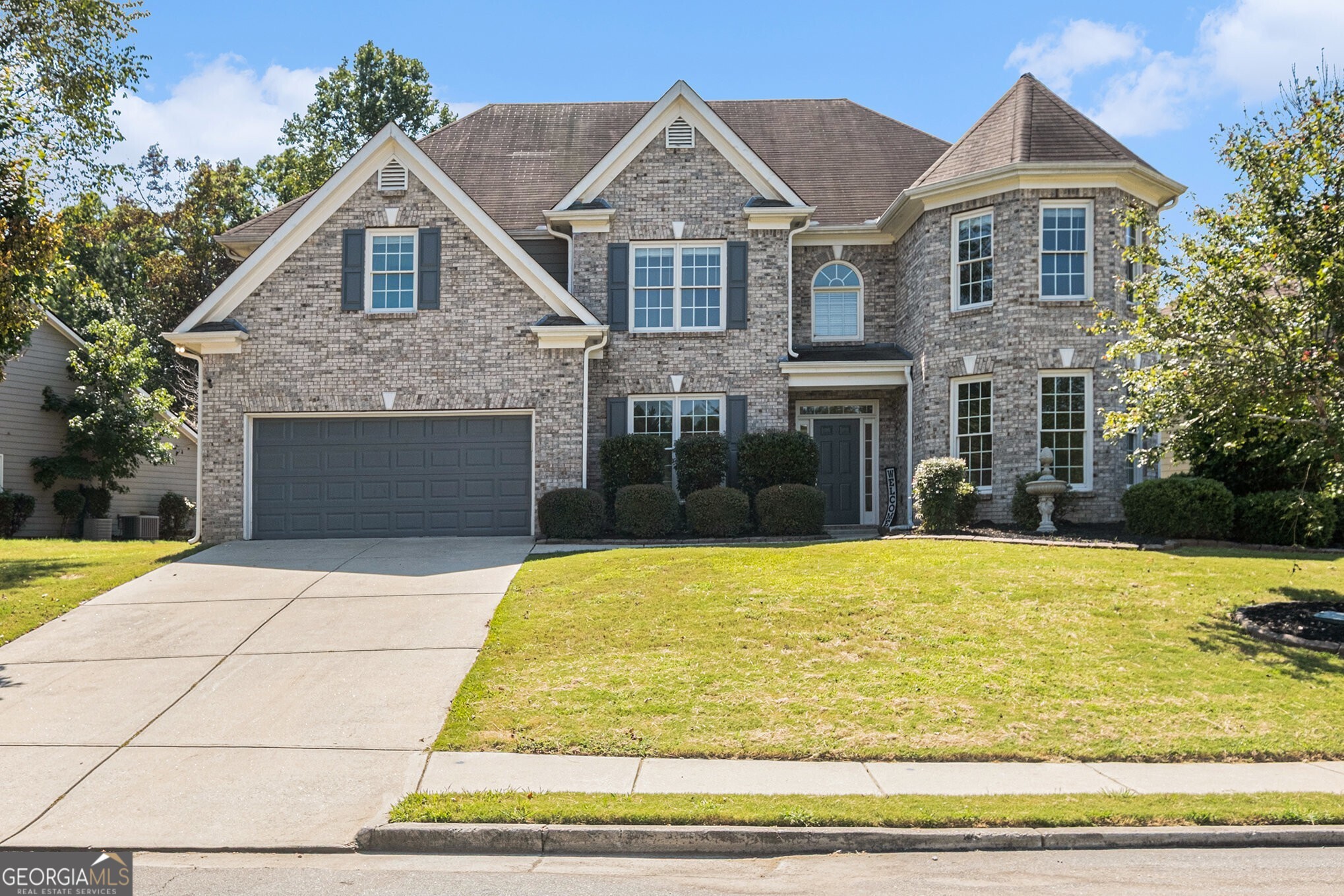 Welcome to your Dream Home perfectly positioned in a beautifully maintained community featuring a Resort-Style Pool, Tennis Courts, Clubhouse, and Playground. Adjacent to the scenic 700-acre Tribble Mill Park, you'll enjoy endless Trails, a Fishing Lake, and wide-open Green Space just minutes from your front door. Starting with Gorgeous Curb Appeal, this Traditional Brick Home boasts a Large Grassy Front Yard and Polished Landscaping. Step inside and be instantly wowed by the Sun-Drenched Two-Story Foyer, Soaring Ceilings, and Hardwood Floors. To your left, an Elegant Formal Dining Room with a Stunning Chandelier and Wainscoting wall details, and to your right, a Bright Formal Living Area with Big Windows and Crown Molding perfect as a Sitting Room, Study, or Office. The Fireside Family Room is the Heart of the Home, showcasing a Coffered Ceiling and seamless views into the Kitchen with a Breakfast Nook, Breakfast Bar for casual meals, Granite Countertops, Stainless Steel Appliances, and Stained Cabinets with a Large Walk-In Pantry. A door leads directly to the Backyard and Patio, making Indoor-Outdoor Dining easy all year round. The Main Level also includes a Bedroom and Full Bath, ideal for Guests or a Home Office. Upstairs, retreat to the Primary Suite featuring a Massive Bedroom with space for a Sitting Area, a Spa-Like Bathroom with Two Closets, a Soaking Tub, Double Vanity with abundant Counter Space, and a Glass Shower. An additional Ensuite Bedroom is located upstairs, along with Two more Bedrooms, another Full Bath, and a Large Walk-In Closet. Laundry completes this level for ultimate convenience. Step outside to a Large Grassy Backyard and Patio perfect for Grilling Out, Gardening, Play, or Entertaining. All of this in the Prestigious Great River at Tribble Mill community, known for its Resort-Style Amenities, Top-Rated Schools, and Thoughtful Floor Plan designed for Elevated Everyday Living. With easy access to Shopping, Dining, Entertainment, and just minutes to the beauty of Tribble Mill Park, this home truly has it all. Don't miss the chance to make this incredible home yours where comfort, convenience, and community come together beautifully.