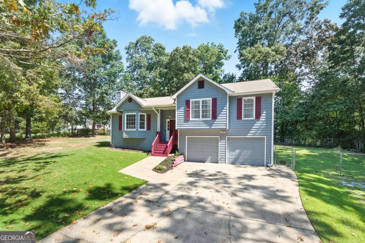 Rare find on almost 1/2 ACRE! One of the largest lots in the neighborhood and one of the larger floor plans! Newer carpet (1 year), interior painted throughout (including dark trim), newer luxury vinyl in both baths and kitchen! The adorable country kitchen has ample cabinet space and stainless steel appliances. The gas range/oven and dishwasher are under 1 year old. Newer fixtures throughout including toilets, lighting, switchplates, door hardware and more! Large primary bedroom with dressing area and walk-in closet. Large secondary bedrooms. Newer blinds and window treatments throughout including roman shades. The basement has great features, daylight in back and partially sheet rocked. This basement is clean and dry - maybe a gym or man pit? Oversized 2-car garage has room for a workshop and plenty of storage. The parking area can be HUGE if you have a boat, camper or work vehicle, this is for you! Huge sunny deck is rustic and so enjoyable with all-day sun and peaceful mornings and evenings. The back yard is fully fenced with a double-gate and a single gate. The HUGE outbuilding has electric and endless possibilities. Stored here are storm windows for all windows of the house (except the kitchen window). The neighborhood has NO HOA, it is friendly and quiet, convenient to Dallas, Cartersville and Acworth. Great new schools in the area too. Schedule your showing today, you won't be disappointed!