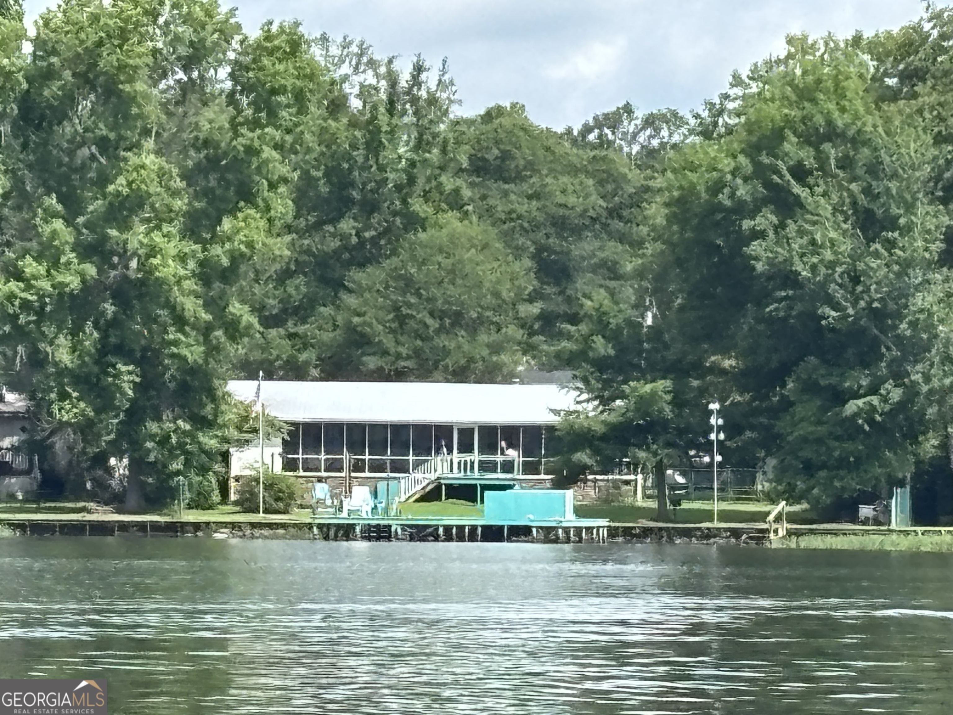Fantastic big water view. Perfect area of the lake. Great plan and layout - no wasted spaces here. Ample sleeping capacity and oversized screened porch for making those memories with family and best of friends. Loved and enjoyed for years. Impeccable condition. Enjoy this great Georgia lake weather for nearly all the months of the year. Level lot and storage buildings for extra space. Best deal on beautiful Sinclair. Enjoy the best fireworks show around from your own dock,yard and porch! Crooked creek fireworks!