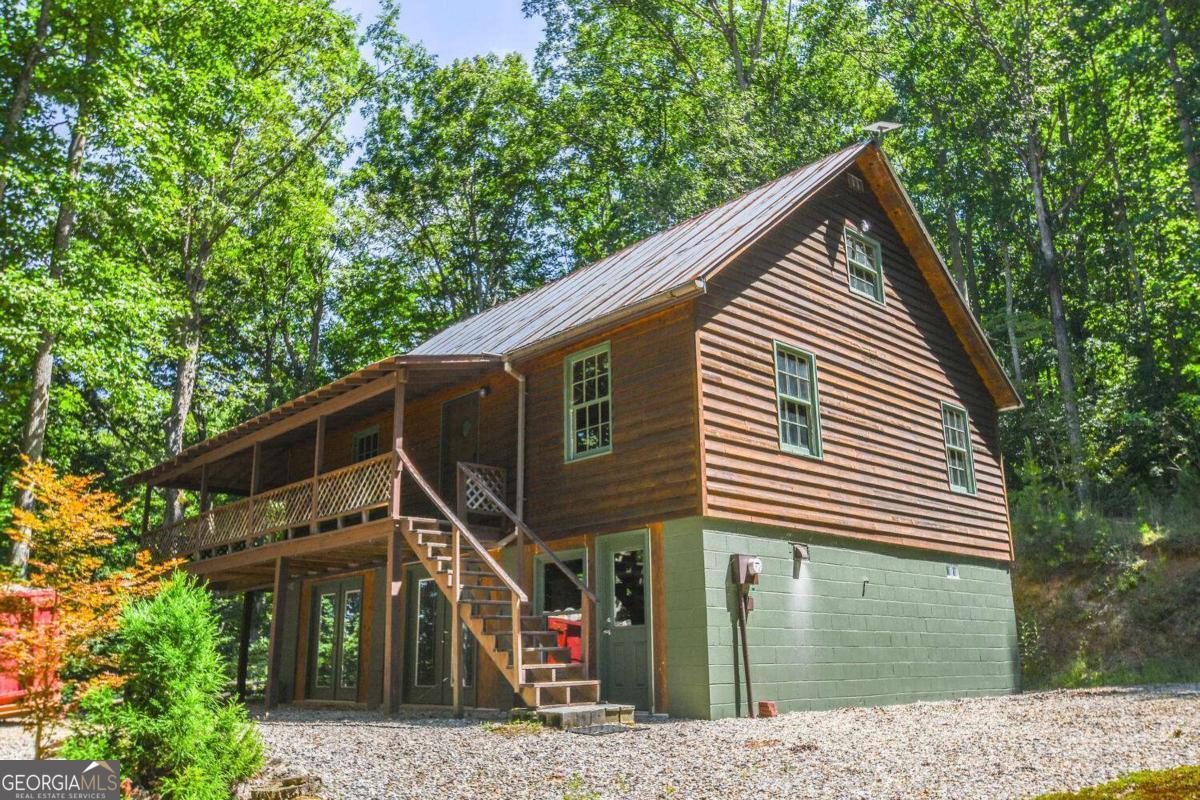 BEAUTIFUL 2 bed/1.5 bath cabin w/loft on FULL BASEMENT! This serene piece of property sits on a peaceful 6.5 acres! MASSIVE basement is full of wood working equipment - it makes an excellent workshop, man cave, storage room, you name it! The basement can easily be converted into additional living space if your heart desires! Wrap around rocking chair porch has amazing views of the woods and lands below! Loft has sleeping area as well as a 1/2 bath! Come see this property before its too late! Priced to move fast!
