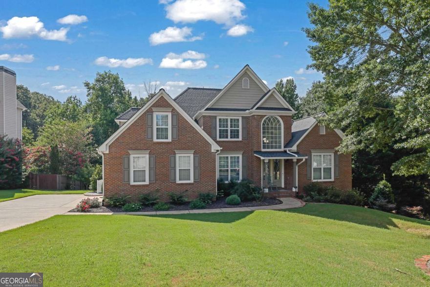 Nestled in the heart of Suwanee's sought-after Ruby Forest neighborhood, this beautifully maintained 4-bedroom, 3.5-bath home offers 3,866 square feet of thoughtfully designed living space. Community amenities include a clubhouse, pool, tennis courts, pickleball, playground, lake, and direct access to George Pierce Park. You're just minutes to Suwanee Town Center, top-rated North Gwinnett schools, shopping, dining, and easy I-85 access. Enjoy a bright, open concept layout with fresh paint and new hardwood floors and new carpet in the bedrooms. The kitchen features white cabinetry, quartz countertops, stainless steel appliances, breakfast bar, and under-cabinet lighting. The primary suite is located on the main level, complete with tray ceilings, a spa-like bath, and spacious walk-in closet. Hardwood floors span the main level, while newer carpet enhances the upstairs, which includes three additional bedrooms - each with generous closets. The finished basement adds versatile living options including a full bath, office, recreation area, and additional flex room - plus an oversized workshop/storage space. Step outside to a private backyard oasis, with extensive decking that overlooks a serene creek, walking to the tennis court and walking trail.