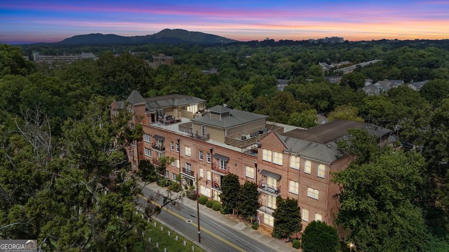 This elegant four-sided brick building makes a striking first impression with its classic design and enduring character. Within the residence, the sophistication continues as you are immediately greeted by the timeless elegance of grand columns that define the dining room as its own sophisticated space. Gleaming hardwood floors, soaring 10-foot ceilings, and an abundance of natural light set the tone for an open and airy floorplan. The great room is both stylish and inviting, enhanced by recessed lighting, custom built-in bookshelves, and a cozy fireplace perfect for relaxing on winter nights. Through French doors, the private patio offers a quiet retreat for morning coffee or evening unwinding. The gourmet kitchen is a chef's dream, boasting Bosch stainless steel appliances, granite countertops, and endless cabinetry. Thoughtfully designed to overlook the great room, it is ideal for both entertaining and everyday living. This is not your typical condo, featuring three bedrooms and three bathrooms, including two primary suites, the home offers remarkable flexibility. Whether you need space for a teen suite, an in-law retreat, or a private office on the opposite side of your bedroom, the possibilities are endless. Both primary bathrooms feature double vanities, while the main suite elevates the experience with a stand-up shower, soaking tub, and dual closets designed for those who love to shop or simply love their own space. Adding to the charm, a Juliet balcony allows you to open the doors to crisp fall air and the sounds of the season. Peace of mind comes easily here, as the HOA covers nearly everything. Exterior maintenance, gas, water, insurance, termite protection, pest control, and trash are all included, allowing you to simply turn on the power and relax. The condo also provides ample visitor parking, a deeded parking spot, and a private storage unit with electrical. For seamless convenience, the elevator carries you directly from the parking garage to your condo and up to the rooftop observatory, where panoramic views provide both tranquility and the perfect backdrop for entertaining. This residence is located just steps from the vibrant Marietta Square, where you can enjoy year-round festivals, concerts, restaurants, art shows, fireworks, and seasonal celebrations for all to enjoy. Outdoor enthusiasts will also appreciate being just minutes from Kennesaw Mountain, offering endless opportunities to hike, bike, or enjoy a leisurely stroll surrounded by nature. With quick access to I-75, only 15 minutes from Truist Park and The Battery, and a boutique community of just 18 units, this home offers the perfect balance of charm, convenience, and exclusivity. Opportunities like this are rare, and finding a home of this caliber, in this location, at this price, is truly extraordinary. All that's missing is you!  ***Be sure to check out the last image. It's a Monthly Expense Equivalency Chart. Condo Convenience vs. Home Independence. $742 a month in HOA dues might look intimidating, but compared to typical   monthly expenses, you're actually coming out ahead by choosing this option!***