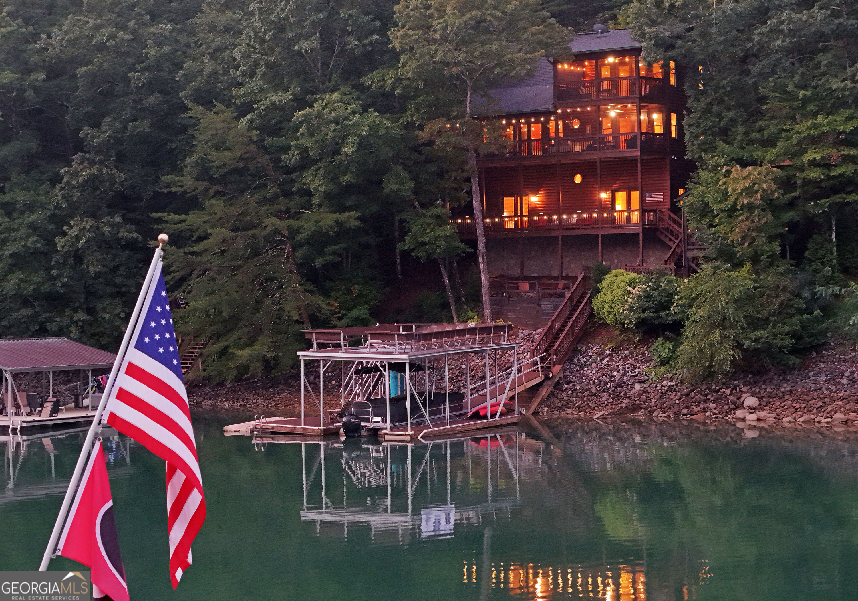 Stunning Lake Blue Ridge Frontage with Breathtaking Long-Range Mountain Views! Welcome to your dream retreat on the shores of Lake Blue Ridge! This exceptional lakefront cabin offers year-round deep water access and sweeping long-range mountain views-all within a peaceful, gated community. Imagine watching the 4th of July fireworks from your deck or cruising across the lake to the Boat Dock Bar & Grill for dinner and drinks. This is lakeside living at its finest. Inside, the 3-bedroom, 3-bath cabin charms with its warm, all-wood interior, soaring windows, gazebo with hot tub and open-concept layout that brings the outdoors in. The spacious kitchen boasts custom cabinetry, stainless steel appliances, and a generous dining area that seats up to 12-perfect for hosting family and friends. Relax in the cozy living room by the stacked-stone wood-burning fireplace, or retreat to the upstairs master suite, complete with a private screened-in porch offering panoramic views of the lake and mountains-ideal for enjoying your morning coffee or evening sunsets. Additional features include Recreation room with extra sleeping space for guests, Central vacuum system & alarm system, Paved driveway leading to a private 2-story boat dock with lift and jet ski ports, Expansive lot with fire pit area tucked among the trees, Ample extra parking for guests. This rare property offers not just a home-but a lifestyle. Whether you're gathering for cozy winter bonfires, enjoying lazy summer days on the lake (boat available for separate purchase), or simply soaking in the year-round views, this is a retreat you'll never want to leave. Don't miss your chance to own a piece of Lake Blue Ridge paradise. Schedule your private showing today!