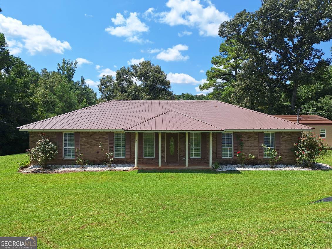 OPEN HOUSE THURSDAY, SEPTEMBER 11TH FROM 4:00-6:00 P.M. EST. Home Sweet Home!! If you are looking for a home with land and animals, this is it!! This charming 4BR/2BA brick ranch sits on over 4 acres with a creek. Inside, you'll find an open concept in the living room and dining area with vaulted ceilings and a beautiful wood burning fireplace perfect for those cool nights. There is a bonus room off of the kitchen that could be used as a breakfast area, an office or playroom. This property is loaded with extras! The home has a fantastic 10'x30' L shaped deck perfect for family gatherings. On the property you have fruit and berry trees that include Apple, fig, mulberry, elderberry, pear, plum, banana, and grapes. There are 5+ raised beds in the front driveway with 7 trellises, all producing fruits and veggies. Along the side of the house, you will find 5+ raised beds producing herbs, flowers, and veggies. Near the playhouse there is a raised bed for garlic and a seasonal tulip patch near the goat enclosure. The property also includes a chicken coop (with a rooster and 10+ chickens), a 40x30 barn with goat stalls currently housing female goats and a male goat, a workshop/office and open space for mowing equipment, a quail coop housing quail, a makeshift dog kennel, and a horse shed and platform near the creek. Wait, I am not done. There is a detached garage with electric garage door opener and a 10X16 storage loft barn, playset, firepit, worm farm, compost bin, and mulch barrels. You could have your very own homestead! Newer roof (2021), Water heater (2023), HVAC (2024) Garage (2021) Deck (2022) Call today and schedule your appointment. This is a must see!!