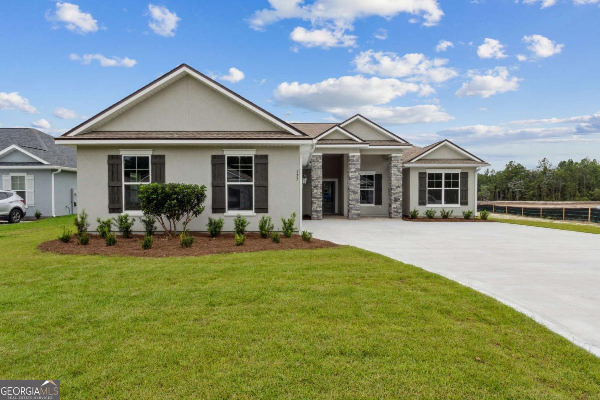 New Construction, move-in ready, and offering buyer incentives with use of preferred lender! This home built by trusted local builder Josselyn Homes is located in the highly sought-after Lake Juniper community-with no HOA. Just 3 miles from local schools, Laurel Island Links, Chick-fil-A, and minutes from I-95, this home offers easy access to Brunswick, Jacksonville, and Kings Bay. Inside, you'll find radiant barrier roof sheathing, recessed lighting, smooth walls with bullnose corners, 9-foot ceilings, granite countertops, stainless steel appliances, custom wood cabinetry with soft close hinges, crown molding, blinds, and EVP flooring in the main living areas with carpet in the bedrooms. The primary suite includes a double vanity, garden tub, separate tiled shower, and a walk-in closet. Enjoy partial pond views from the backyard, creating a serene outdoor setting. The exterior features low-maintenance Stucco siding, an extended driveway for extra parking, gutters, and an oversized 2-car courtyard garage with a WiFi-ready automatic door opener. Seller is related to the listing broker.