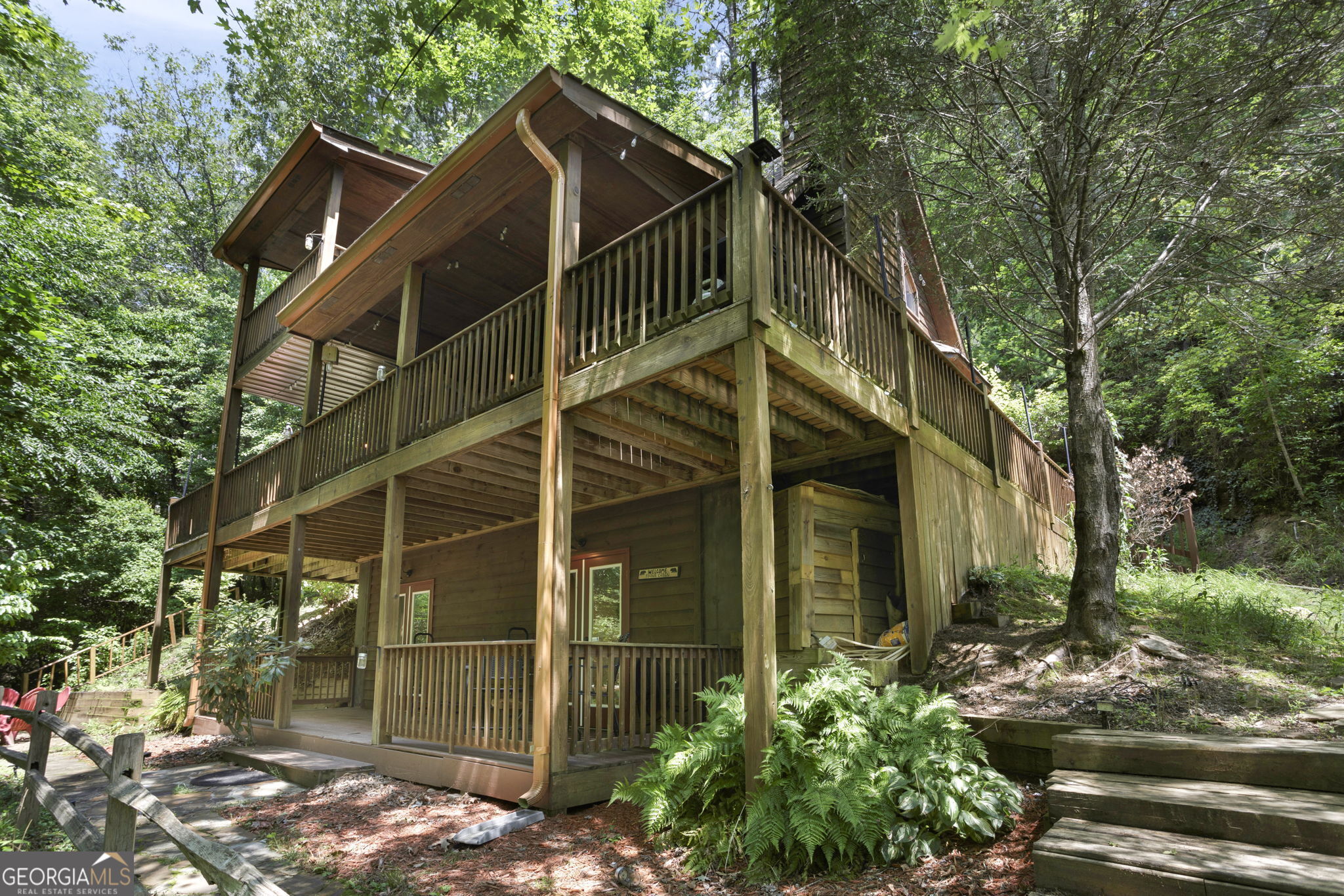 Escape to your private mountain retreat! This beautifully maintained **3 bed, 3 bath cabin-style home** sits on a **wooded 1-acre lot** and is a thriving **fully furnished short-term rental**-ready for immediate income or your personal getaway. Step inside and fall in love with the **warm wood siding**, **tongue-and-groove cathedral ceilings**, and a **cozy wood-burning fireplace** that anchors the open living space. Enjoy seamless indoor-outdoor living with **three tiers of spacious decks**, each offering breathtaking views and the peaceful sounds of a **large, flowing creek**-which you **own the rights to use and play in**! Soak your worries away in the **private hot tub on the porch**, surrounded by nature and serenity. Every inch of this home was designed for comfort and relaxation, from the well-equipped kitchen to the restful bedrooms with wooded views. Located in a desirable vacation market, this cabin is **turnkey and busy**, with a strong rental history and everything you need to continue hosting guests. Whether you're looking for an investment or a personal haven, this property checks every box. **Don't miss your chance to own a slice of Appalachian paradise-schedule your showing today!**