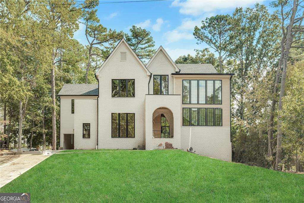 Come see this inviting new construction home nestled in a prime Sandy Springs location, offering the perfect blend of elegance, comfort, and modern living. Step through the portico arch entry into a grand foyer with soaring 10-foot ceilings and stunning hardwood floors that flow throughout the home. The main level features a guest suite with a full bath, a separate dining room with vaulted ceilings-ideal for entertaining. The heart of the home is the designer kitchen, complete with top-of-the-line appliances, custom cabinetry, and a spacious scullery, all overlooking the family room and a cozy fireplace. A mudroom off the kitchen adds convenience, while thoughtful design elements create a seamless flow for everyday living. Upstairs boasts vaulted bedrooms, and a luxurious primary suite with a spa-like bath featuring custom walnut double vanities, a soaking tub, separate shower, and large walk-in closet. The upper level also includes three additional ensuite bedrooms and a convenient laundry room, providing space and functionality for family and guests. Enjoy outdoor living at its finest with a covered porch featuring a fireplace overlooking a private backyard with plenty of room for a POOL. This 5-bedroom, 5.5-bath home also includes a 3-car garage and an UNFINISHED basement-offering endless potential for customization to suit your lifestyle. Perfectly situated in the heart of Sandy Springs, this home combines the tranquility of a private setting with the excitement of nearby premier shopping, dining, and entertainment. Every detail has been thoughtfully designed to offer both comfort and sophistication in one exceptional home.