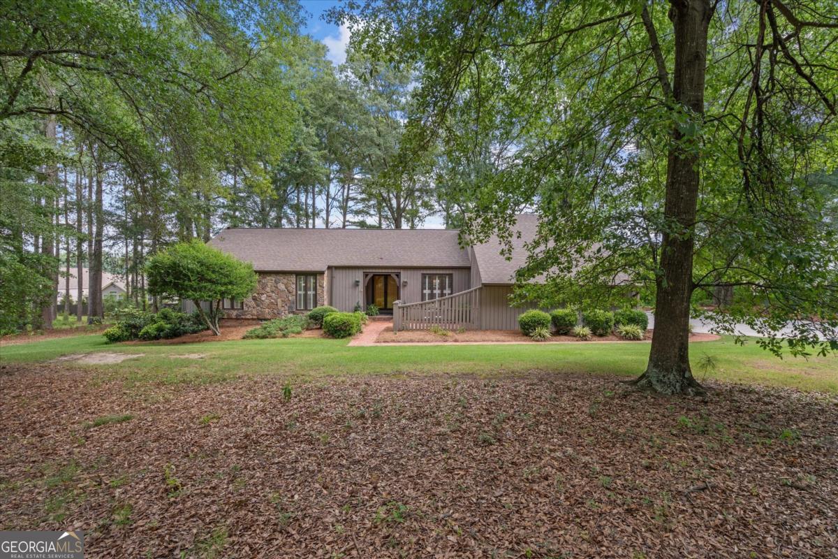 It's not every day a classic mid-century modern home hits the market! Tucked away on a serene and private lot, this hidden gem is being offered for the first time by its original owner and has been exceptionally well maintained. Designed with entertaining in mind, the home features separate areas to relax and unwind-including a sunny Florida room with a wall of windows that walks out to the covered back porch, and an expansive deck overlooking the peaceful private yard. Inside, you'll find timeless quality throughout, including solid wood panel doors, beautiful molding, and a vaulted tongue-and-groove wood ceiling in the great room, complete with oversized gas logs. The dining room showcases a hand-painted mural, adding charm and character, while the kitchen offers a stone island, large pantry, and ample cabinetry. The home includes 3 bedrooms and 2 full baths, all with large walk-in closets, as well as a spacious walk up bonus room, approx 223 +- sq ft, and walk-in attic space. Additional highlights include Pella Peachtree double-pane windows, 8-inch channel rustic siding, plantation shutters, transom windows, a newer roof, and a large laundry room with extra storage. Outside, enjoy the welcoming front covered porch and sitting area, a separate garage/workshop/man cave with shop bench, a new door, and a huge parking pad. And best of all-no HOA! A rare opportunity to own a truly special home that combines classic mid-century charm, thoughtful updates, and privacy in a peaceful setting.
