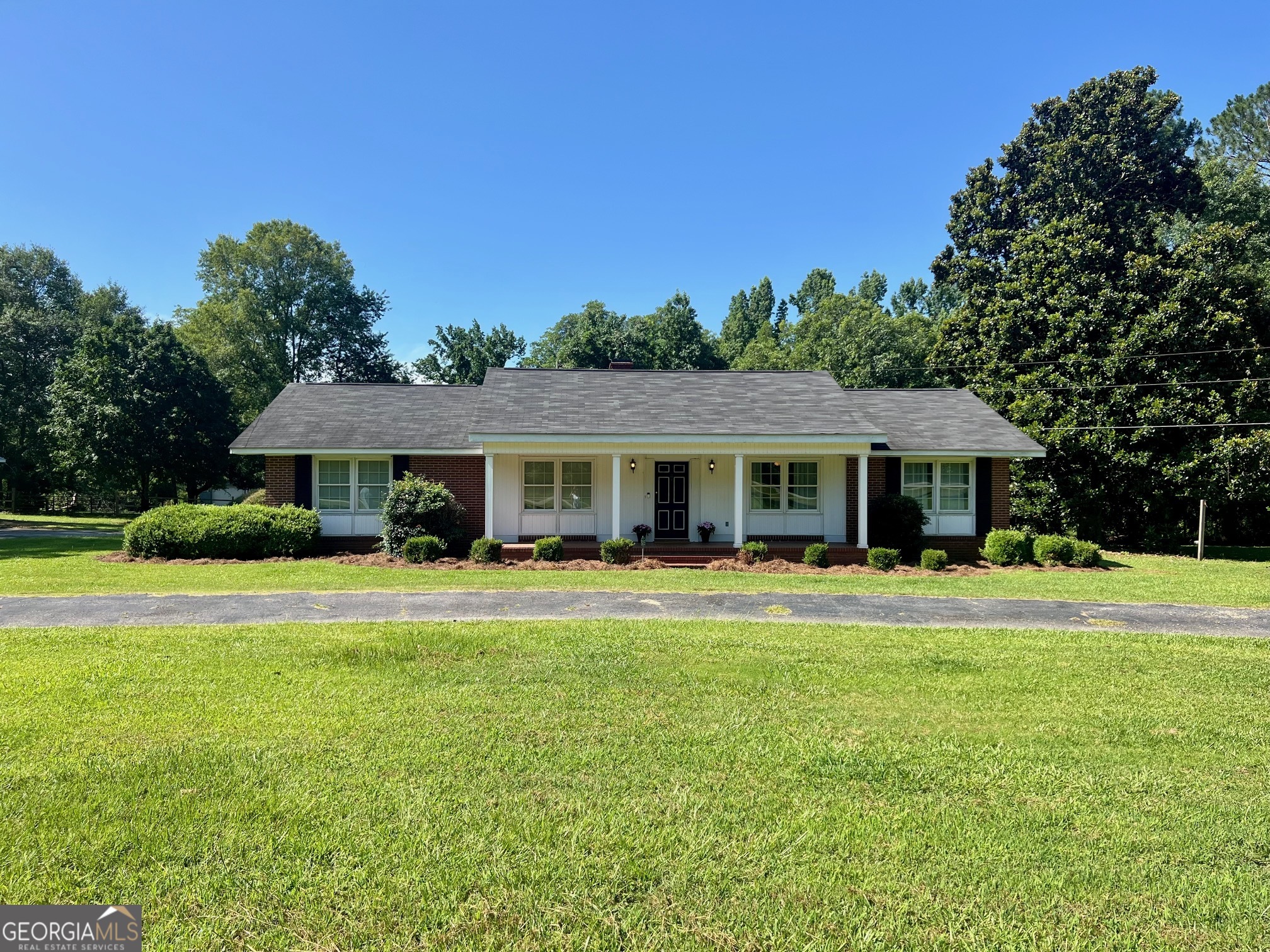 Welcome to 1282 E McCarty St. in Sandersville, Ga! This 4-sided brick home sits on 14.5 acres with a beautiful pond. Home features 3 bedroom/2 bath, living room, family room with gas fireplace and a large screened in back porch. Home has city water and a septic tank, but city sewer is available. Outside you will find multiple storage buildings and a fenced pasture area. Also included is a 40X11 concrete pad (2023) and a large metal building with a roll up door that sits on a concrete slab. If you enjoy relaxing, the front porch is the perfect place to do just that. As you are enjoying the outdoors you will likely come across deer, turkey and ducks. This property offers a rare mix of acreage, water and convenience to town. Call today to schedule your showing!