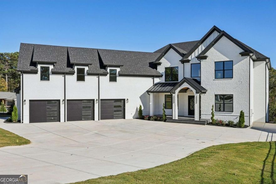 Experience refined living in this custom 6 bedroom, 7 bathroom estate, privately nestled on a fully fenced 1 acre lot with a SEWER connection. Boasting over 6,500 square feet and a full unfinished daylight basement, this home offers the perfect blend of elegance, functionality, and space. A grand foyer sets the tone with soaring 10 foot ceilings, wide plank hardwood flooring, and meticulous custom tile and trim work throughout. The open concept design centers around a true chef's kitchen featuring high end appliances, a 48 inch built in refrigerator, double quartz countertops, a stunning waterfall island, and a full second prep kitchen ideal for seamless entertaining. The kitchen flows into a dramatic 22 foot living room with custom built ins, a cozy fireplace, and bi folding doors that fully open to the covered back deck, creating the ultimate indoor and outdoor living experience. The expansive covered porch features a built in outdoor kitchen and provides year round enjoyment overlooking the private backyard, perfect for gatherings with plenty of space for a future pool or personal outdoor oasis. This thoughtfully designed layout includes two luxurious primary suites, one on the main level and one upstairs, each offering spa like en suite bathrooms with upgraded electric smart toilets and premium finishes. Upstairs also features four additional oversized secondary bedrooms with private baths, a separate office, and a second laundry room that complements the main level laundry for ultimate convenience. Designed with comfort, lifestyle, and efficiency in mind, the home includes a whole home integrated audio system, energy efficient systems, a tankless water heater, and irrigation in both the front and back yards. The fully fenced property provides privacy and peace of mind, and the SEWER connection adds long term value and convenience. Perfectly positioned near Highway 985, Highway 85, Downtown Buford, the Mall of Georgia, and a wide selection of premier shopping and dining options, this estate delivers luxury living with exceptional accessibility.