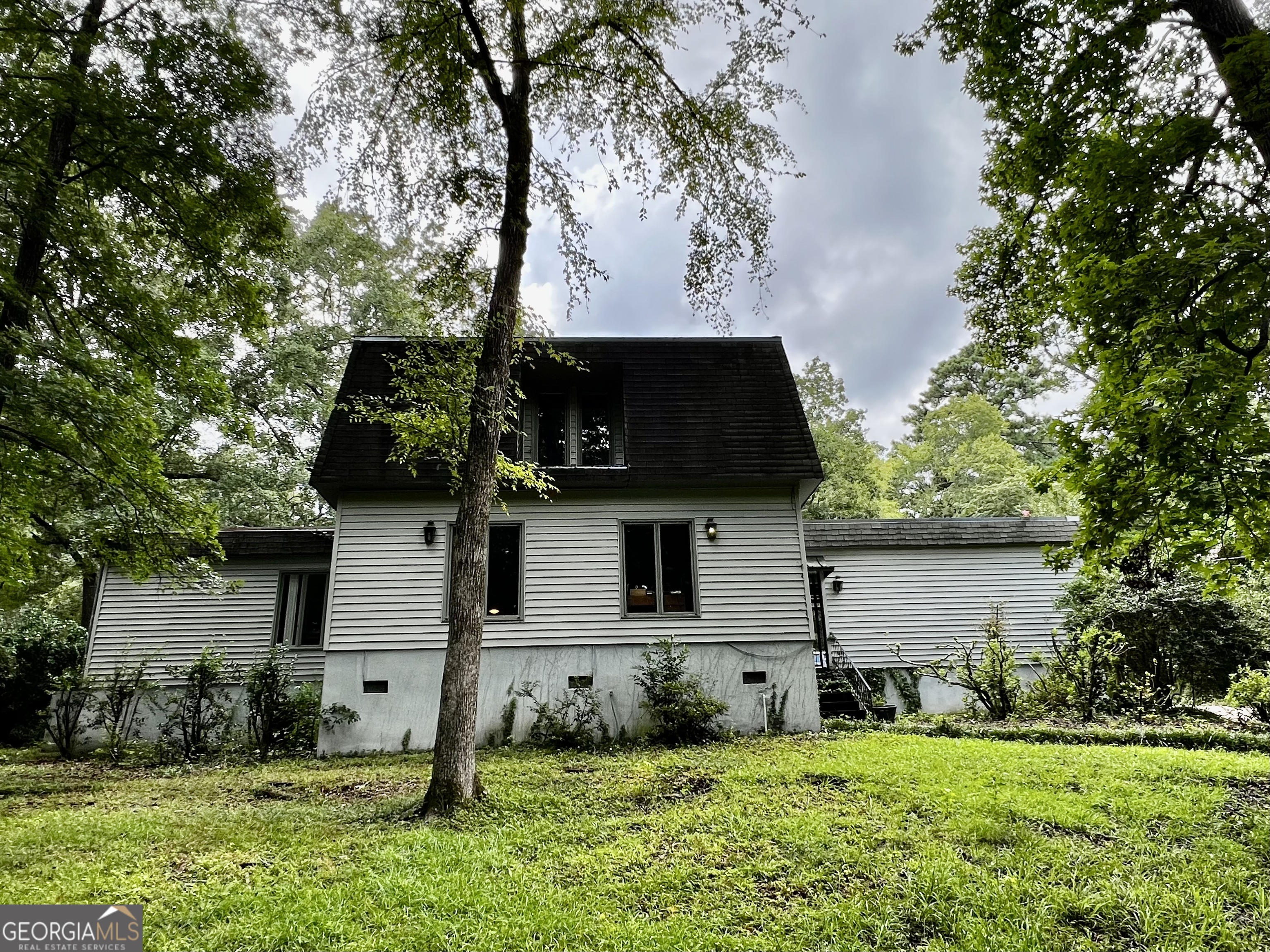 Just listed! This 2-story contemporary-style home sits on nearly 1 acre in desirable North Macon. The spacious family room boasts a wood-burning fireplace with brick facing, gleaming hardwood floors, and French doors opening to a covered back patio. The sunken living room features large windows, flowing seamlessly into a dining area with a convenient wet bar. The kitchen includes all appliances and a cozy breakfast nook. A large laundry room with ample pantry space connects to a screened-in back porch, perfect for relaxing. Upstairs, you'll find three oversized bedrooms and two full bathrooms, plus a convenient half bath on the main level. The fenced-in backyard offers plenty of space and potential. Connected to city water and sewer. Priced to sell "as is," this home needs some TLC, making it a great opportunity for buyers. Call today to schedule a viewing!