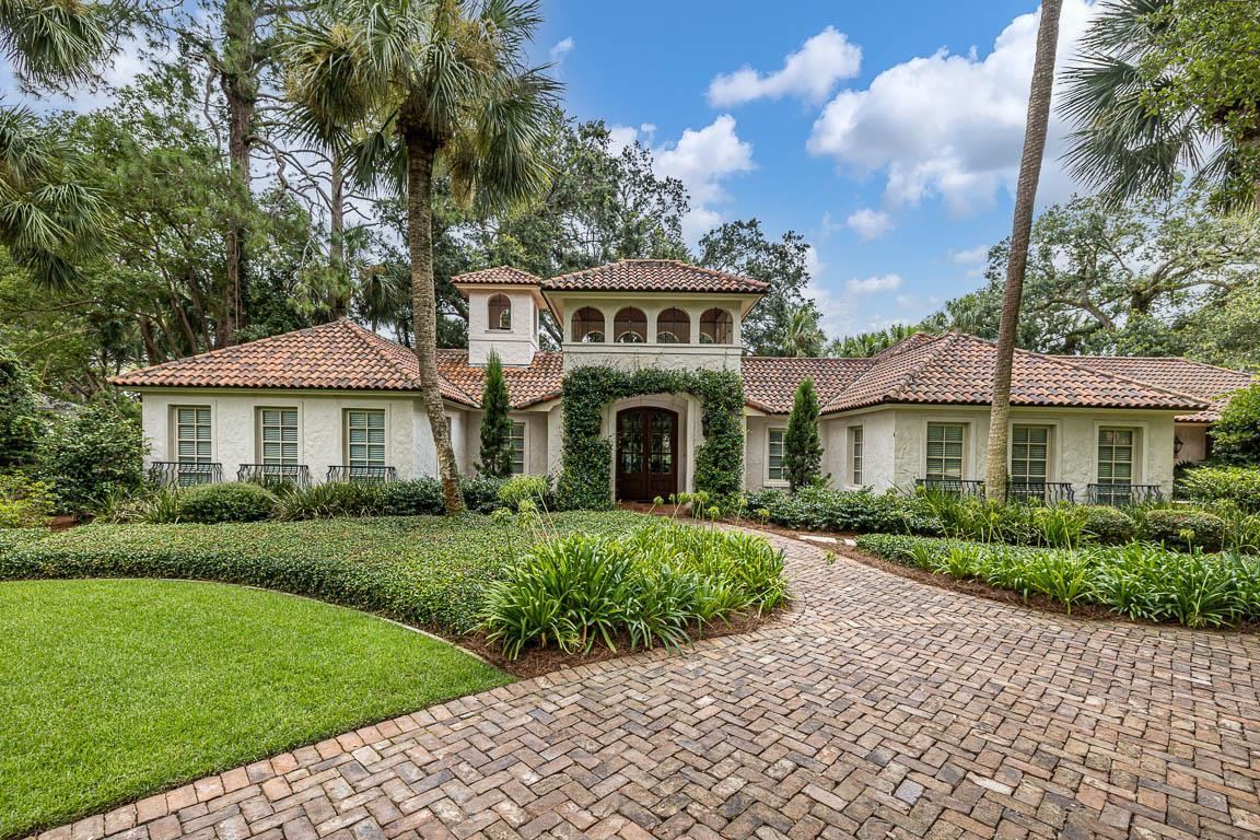 This one-level Mediterranean style home oozes old world elegance and features classic elements. Recently renovated throughout with custom millwork, beamed & tongue-and-groove ceilings, wood and tile floors, and more. Four bedrooms – the spacious master retreat boasts an enviable en-suite and one of the guest retreats is a bunk room that comfortably sleeps 4 (and has a private bath). The gourmet kitchen with a Dacor range & oven, Viking refrigerator, and built-in wine cooler is tucked in between the dramatic living room, sitting room, and formal dining. Formal and casual dining spaces and easy flow from indoor to outdoor living with several French doors that open to the pool deck and grilling patio. The exterior of the home blends the seaside locale with a beautiful tiled roof, textured walls, iron features, and brick paved driveways and sidewalks. The private pool, water feature, and spacious patio are surrounded by lush landscaping, majestic oaks, and palm trees. Two car garage.