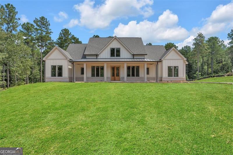 Harmony Bay at Lake Oconee - 2025 Custom Single-Story on 1.75 Private Acres Brand new home just completed inside the gated community of Harmony Bay, this single-level custom home offers refined lake-area living on 1.75 private acres. With 5 bedrooms and 4.5 baths, the design blends craftsmanship with casual elegance in an effortless, open layout. The vaulted great room draws the eye with wood-beamed ceilings and a dramatic floor-to-ceiling brick fireplace-an inviting centerpiece for everyday living and entertaining. The designer kitchen impresses with ZLINE stainless steel appliances, custom cabinetry, an oversized island, and a spacious walk-in pantry complete with a wine refrigerator-equal parts beautiful and functional. The private primary suite is a serene retreat featuring a spa-inspired bath with a freestanding soaking tub, floor-to-ceiling tiled shower, double vanities, and a generous walk-in closet. Guest accommodations include three secondary bedrooms on the opposite wing with access to beautifully finished baths, plus an additional bedroom that flexes easily for guests, office, or media. Step outside to expansive covered outdoor living with a wood-burning fireplace and a large, private backyard-plenty of room to add a custom heated saltwater pool. An oversized boat garage keeps watercraft and lake gear neatly stowed. Enjoy Harmony Bay's private community boat ramp for effortless lake days, along with a prime location minutes from Lake Oconee's top restaurants, schools, shopping, and golf.