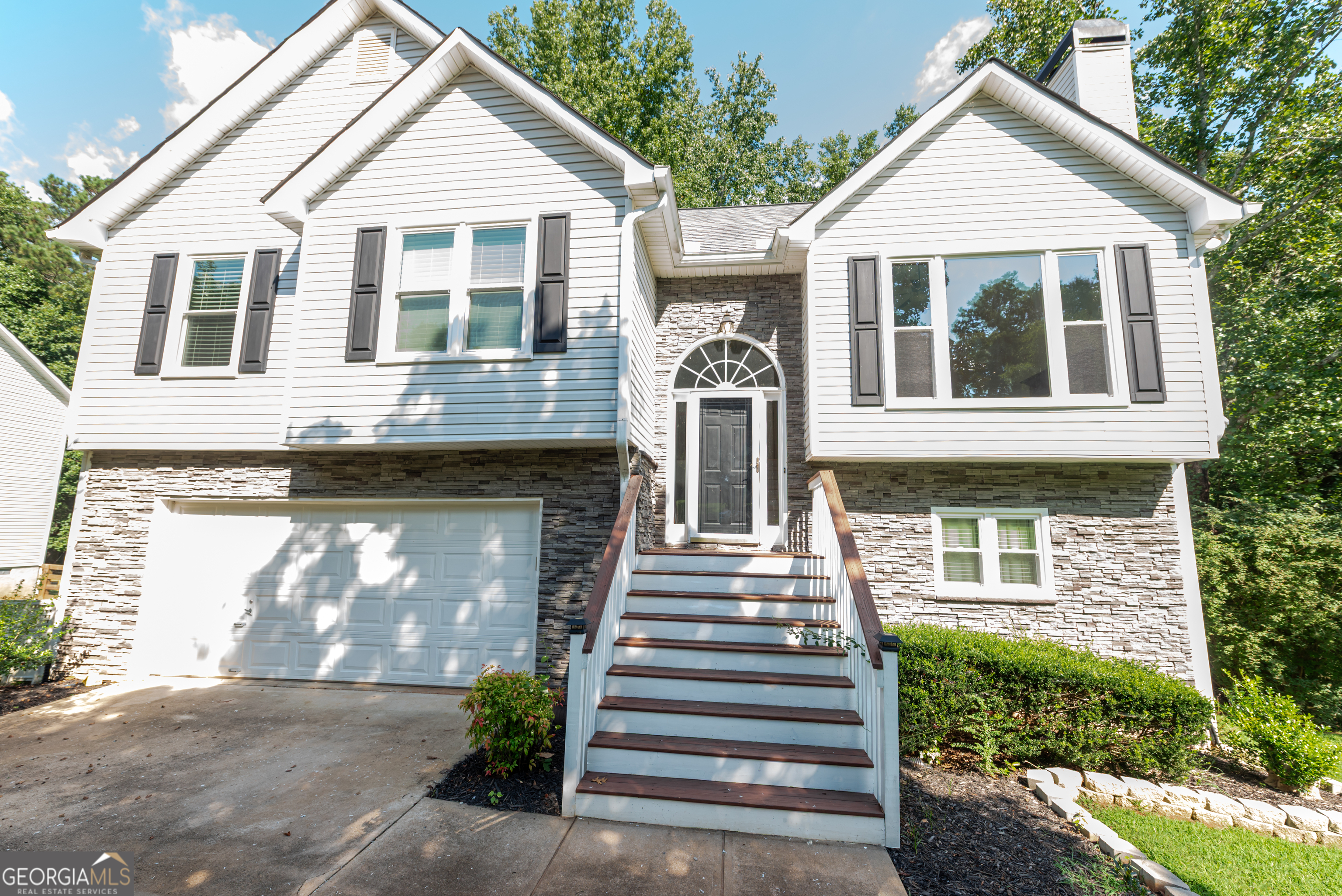 Nestled on nearly an acre in a peaceful, sought-after neighborhood located near great schools, this beautifully updated 3-bedroom, 3-bath home offers the perfect balance of elegance, comfort, and functionality. From the moment you arrive, the curb appeal will impress - brand-new front windows framed by stunning stone masonry create a timeless exterior that sets the tone for what's inside. Step through the front door into a bright and inviting living space. The heart of the home is the expansive living room, where 17-foot ceilings and rich hardwood floors create an open, airy atmosphere filled with natural light. The seamless flow leads to a modern kitchen designed with style and practicality in mind. Complete with sleek marble countertops, updated faucets, and abundant storage, this kitchen is ideal for everyday meals and special gatherings alike. The luxurious master suite is a true retreat, featuring vaulted ceilings and a spa-inspired bathroom with a large, updated walk-in shower and a double vanity. Each additional bedroom has been refreshed with brand-new carpet and paint, ensuring a move-in ready experience for the entire family. Entertainment is effortless in the fully finished basement, which offers a built-in wet bar and direct access to a charming screened-in porch - the perfect space for game nights or relaxed evenings. On the main level, a spacious deck overlooks the large backyard, providing even more room for outdoor living, grilling, or simply enjoying the privacy and serenity of your surroundings. Practical features haven't been overlooked - a two-car garage offers plenty of storage, while the recent updates throughout the home ensure peace of mind and lasting value. Whether you're looking for a quiet escape or a place to host family and friends, this home is designed to meet every need. With its combination of modern upgrades, thoughtful design, and a picturesque setting, this property is more than just a house - it's the place you'll be proud to call home.